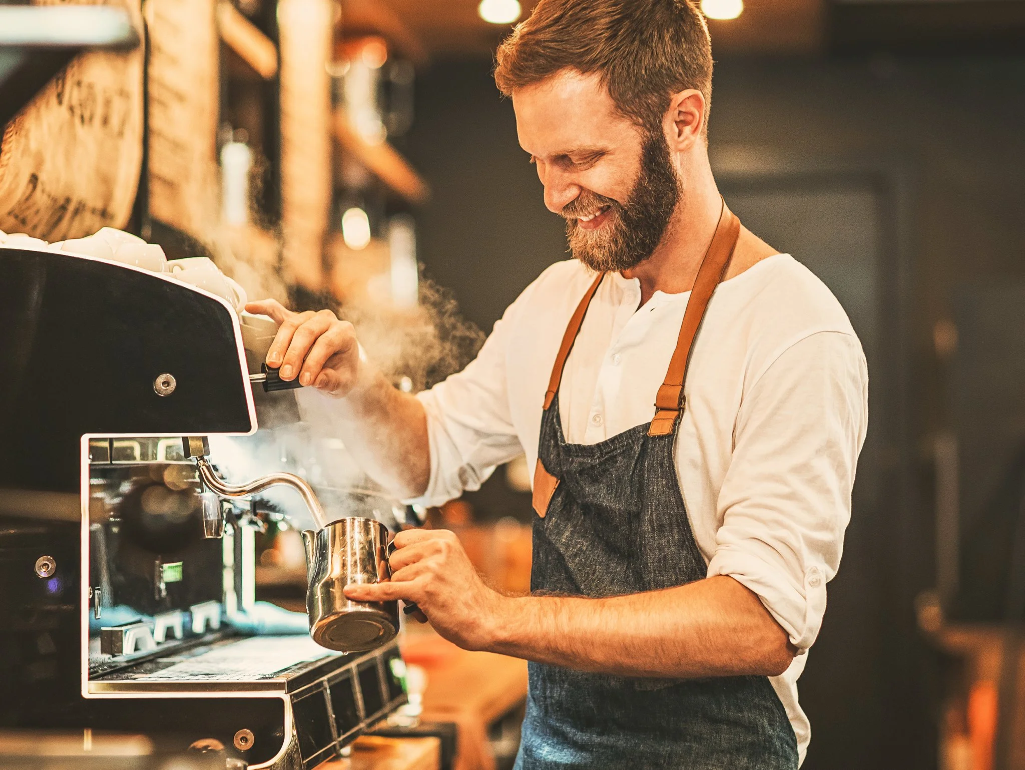 Man bereidt koffie in een koffiezetapparaat in een gezellige koffiezaak.