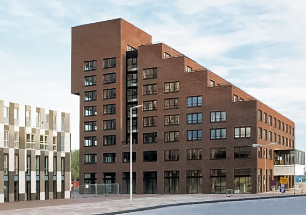 Een modern, roodbruin appartementencomplex met grote ramen en een unieke, geclusterde vorm, gelegen aan een straat met een voetpad en straatverlichting.