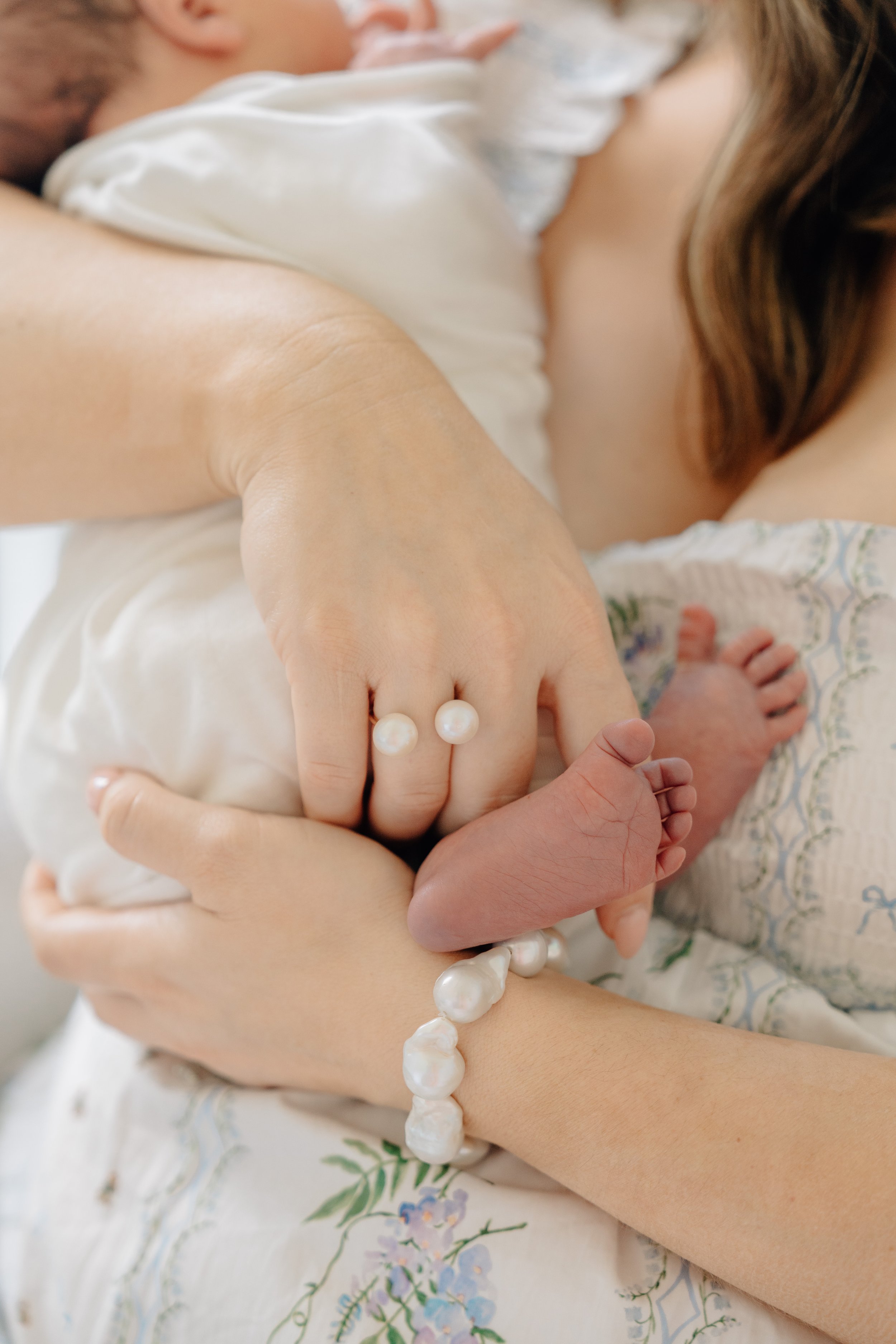 Newborn baby feet photographed with heirloom pearls.