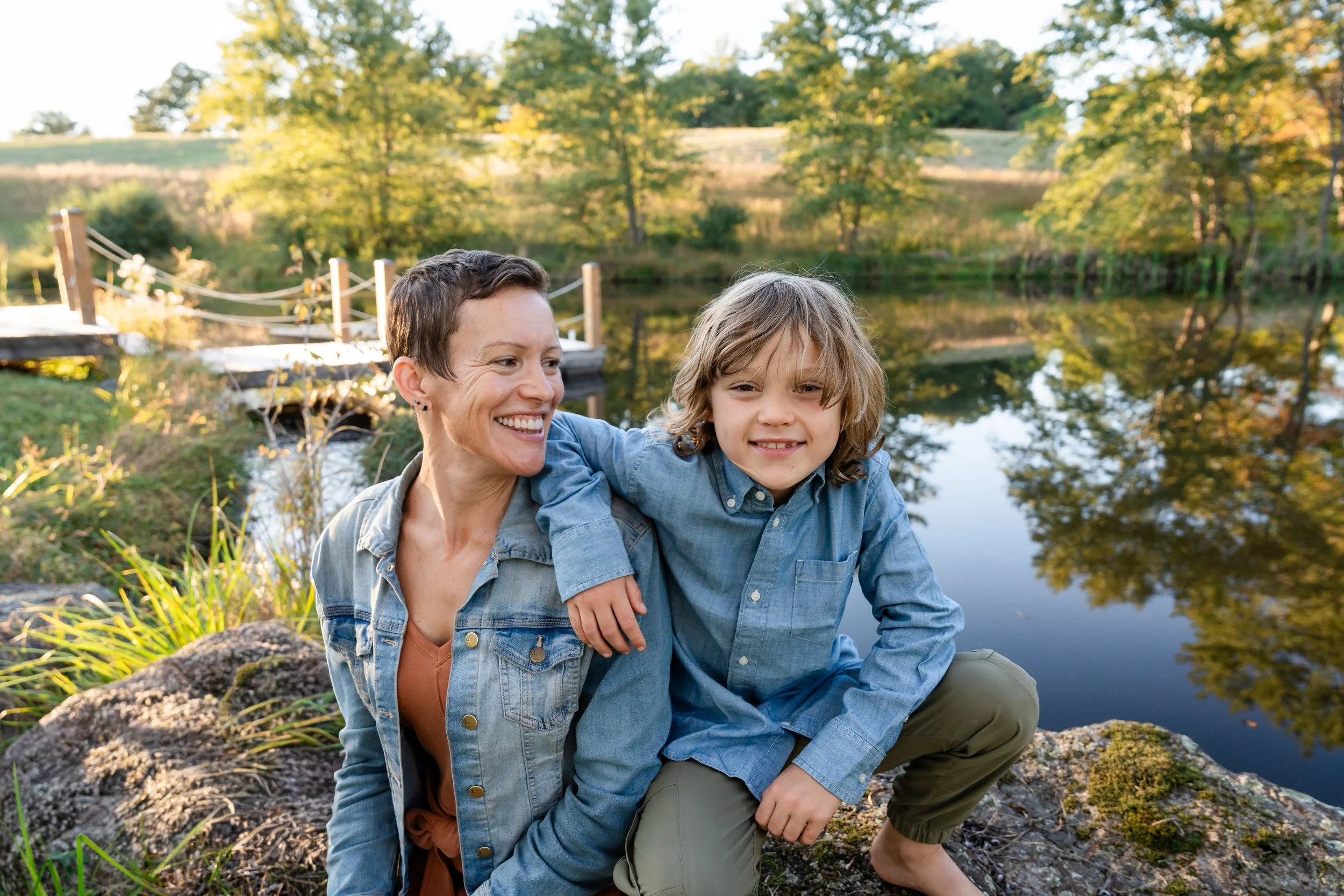  Mother spending a quiet moment with her son on the rocks beside the pond at Grey Oaks Farm. 