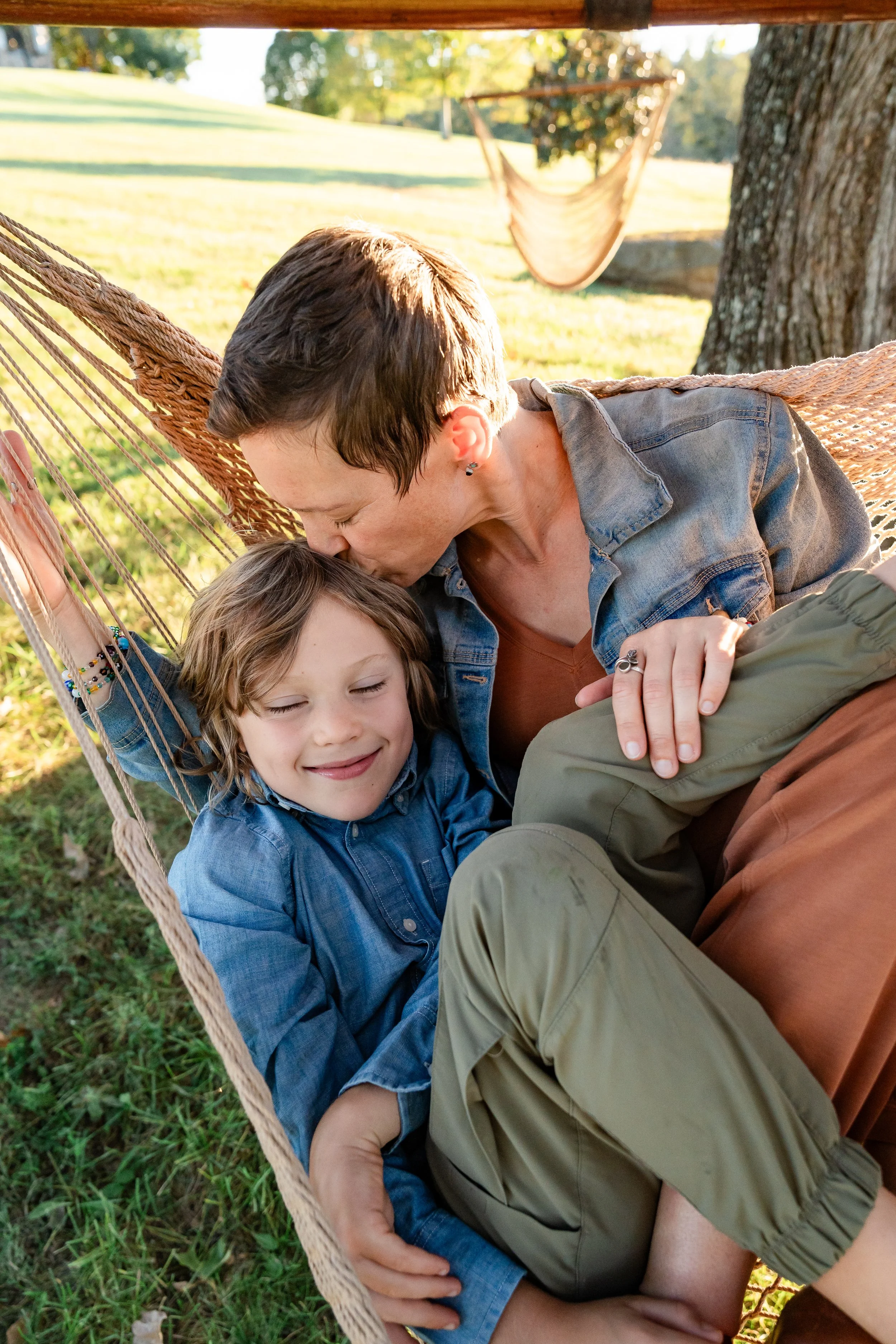  Mother kissing her son while they cuddle together in a hammock during their Charlottesville family photo session. 