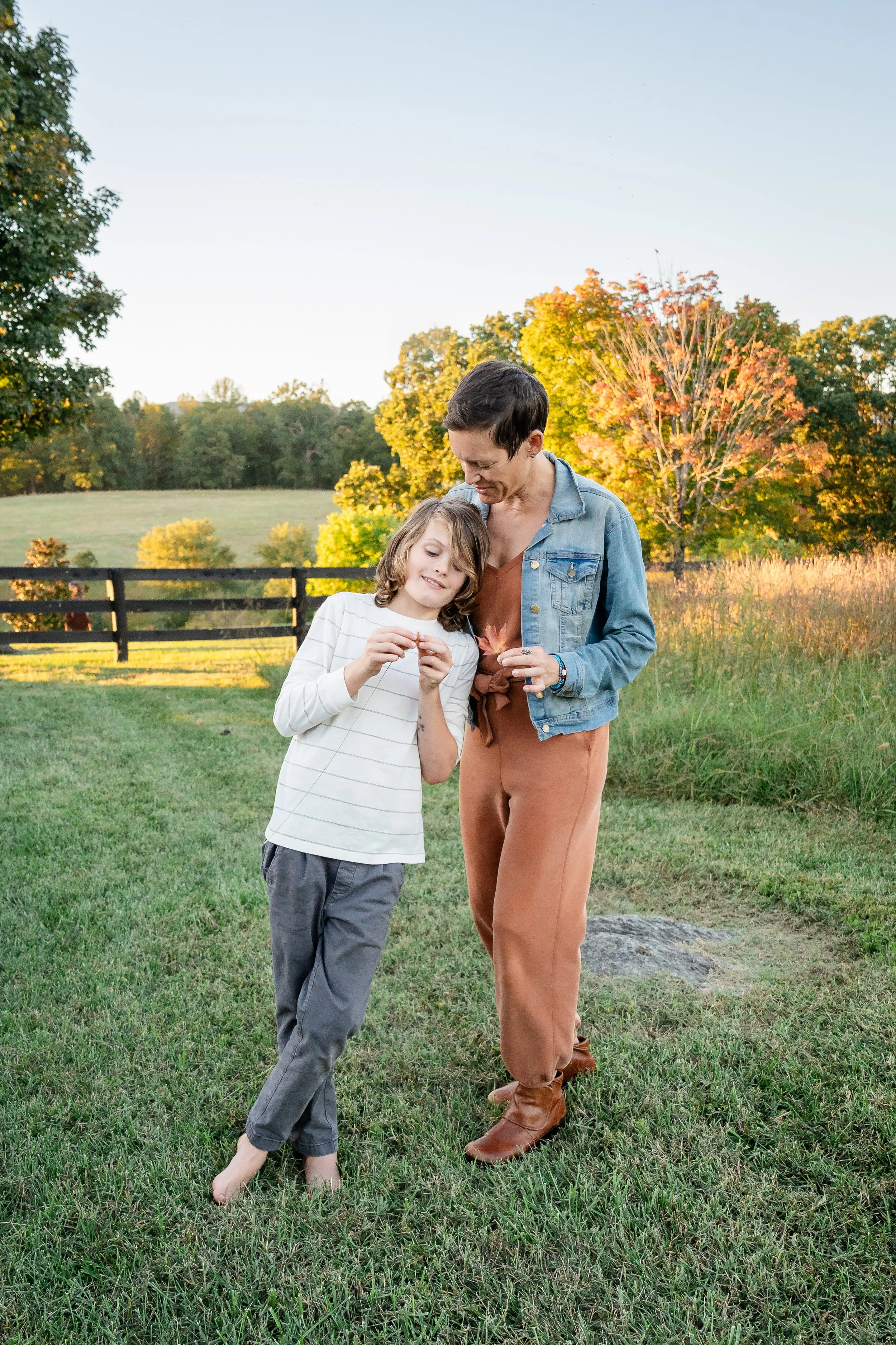  Mother and son sharing a tender moment with a flower during their outdoor family photography session. 