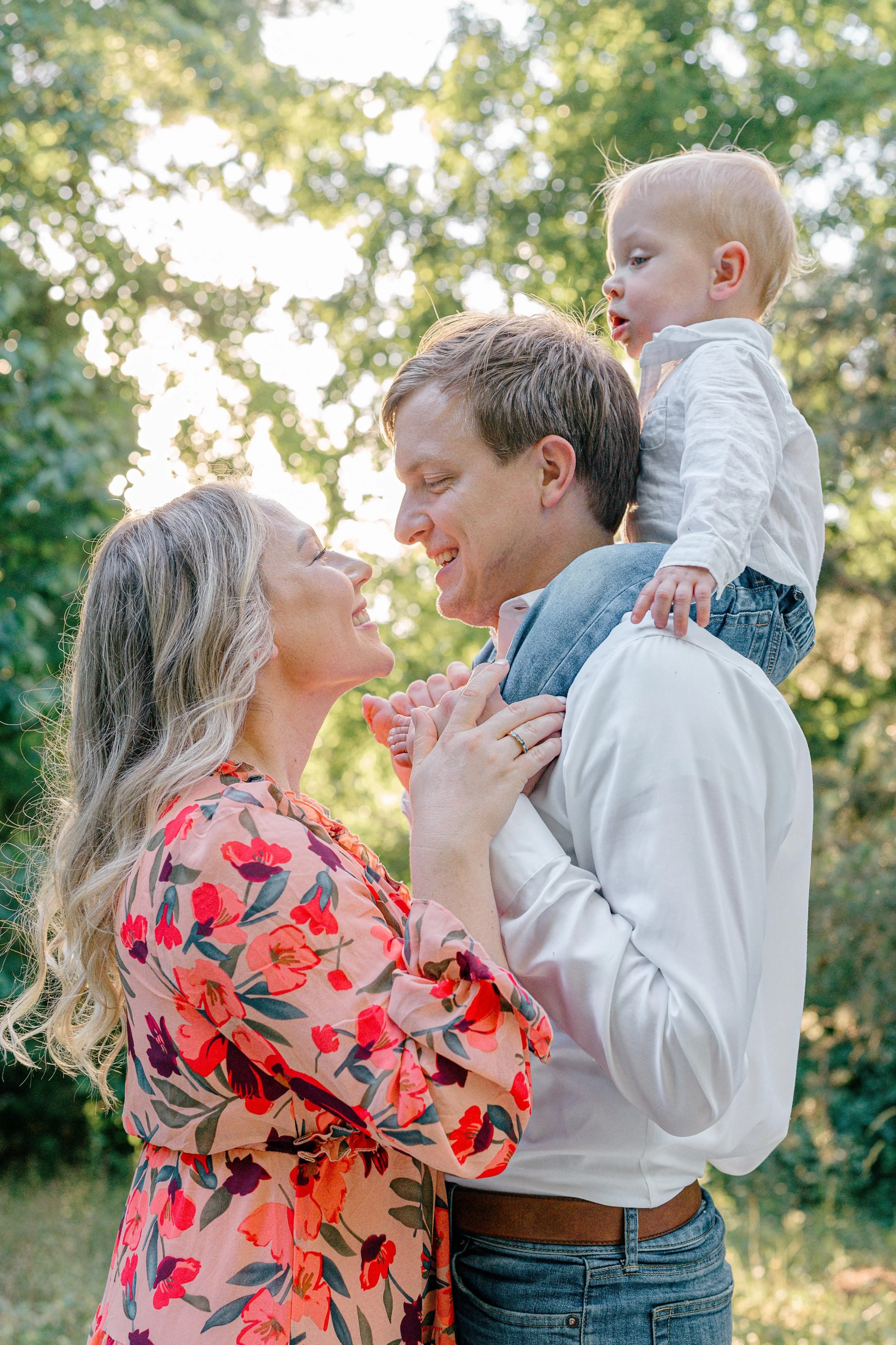Family laughing together during a Charlottesville, Virginia family session with their baby on dad's shoulders