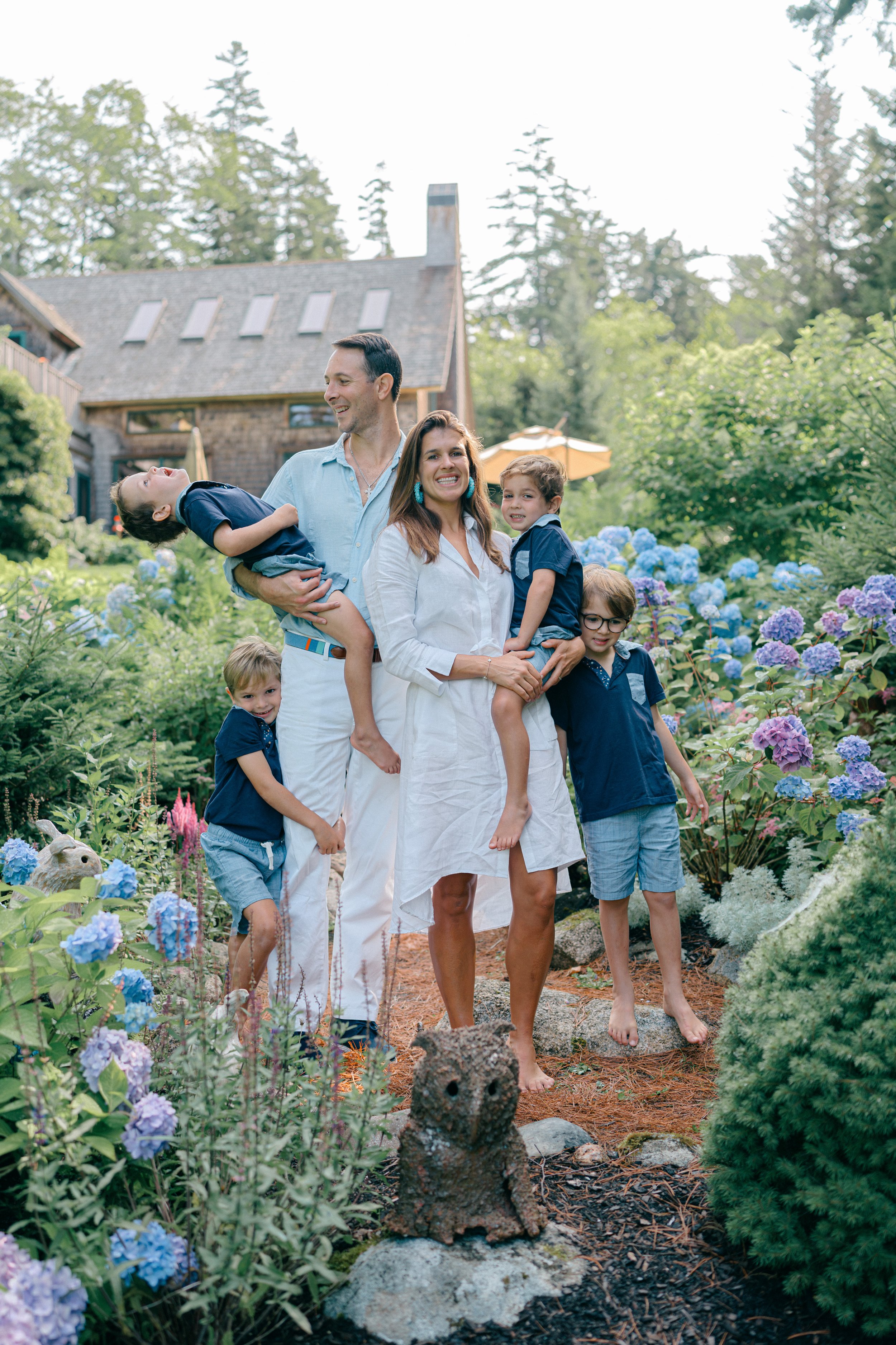 Family standing together among blue hydrangeas during a Maine family photography session