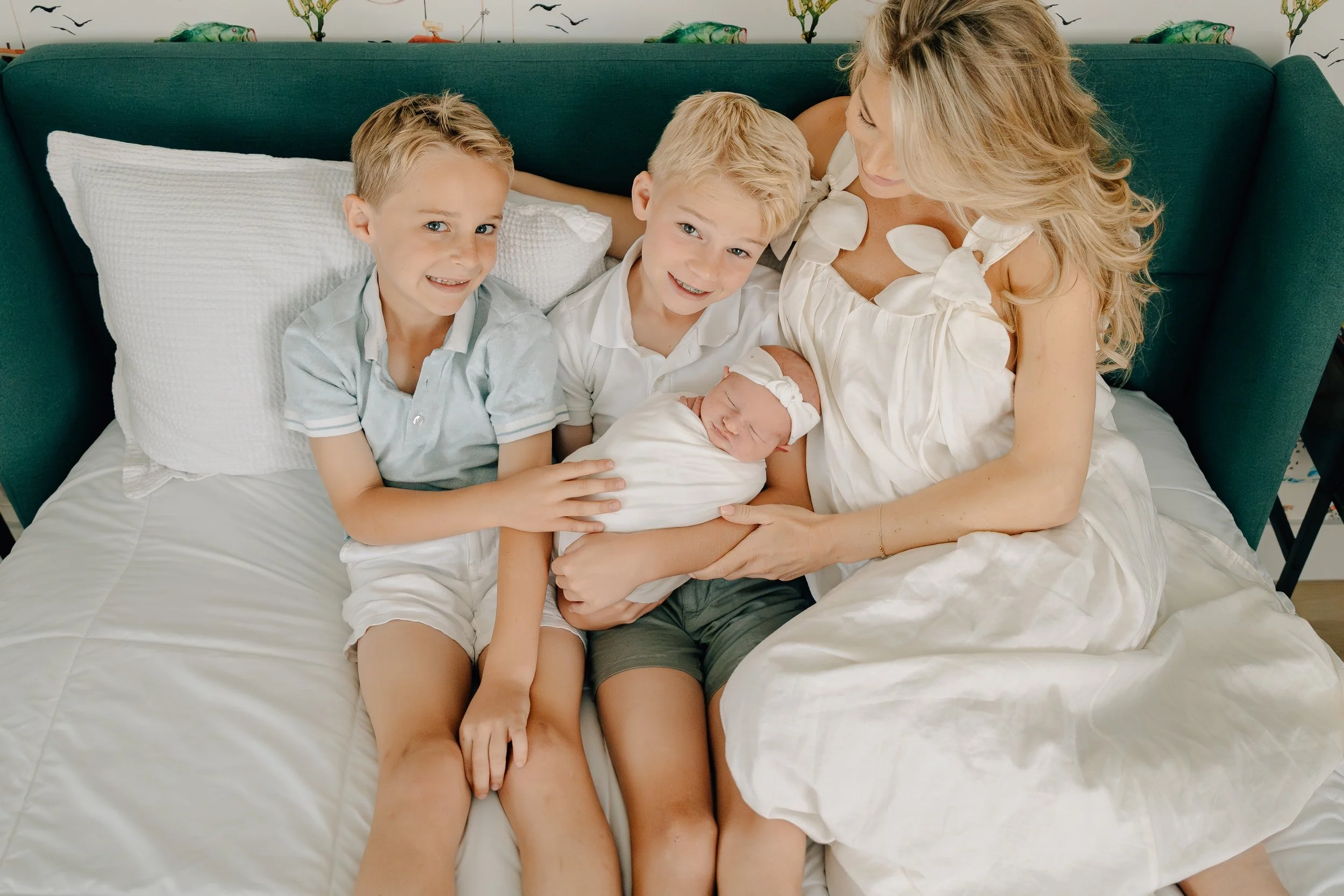 Family of five cuddled together on a bed