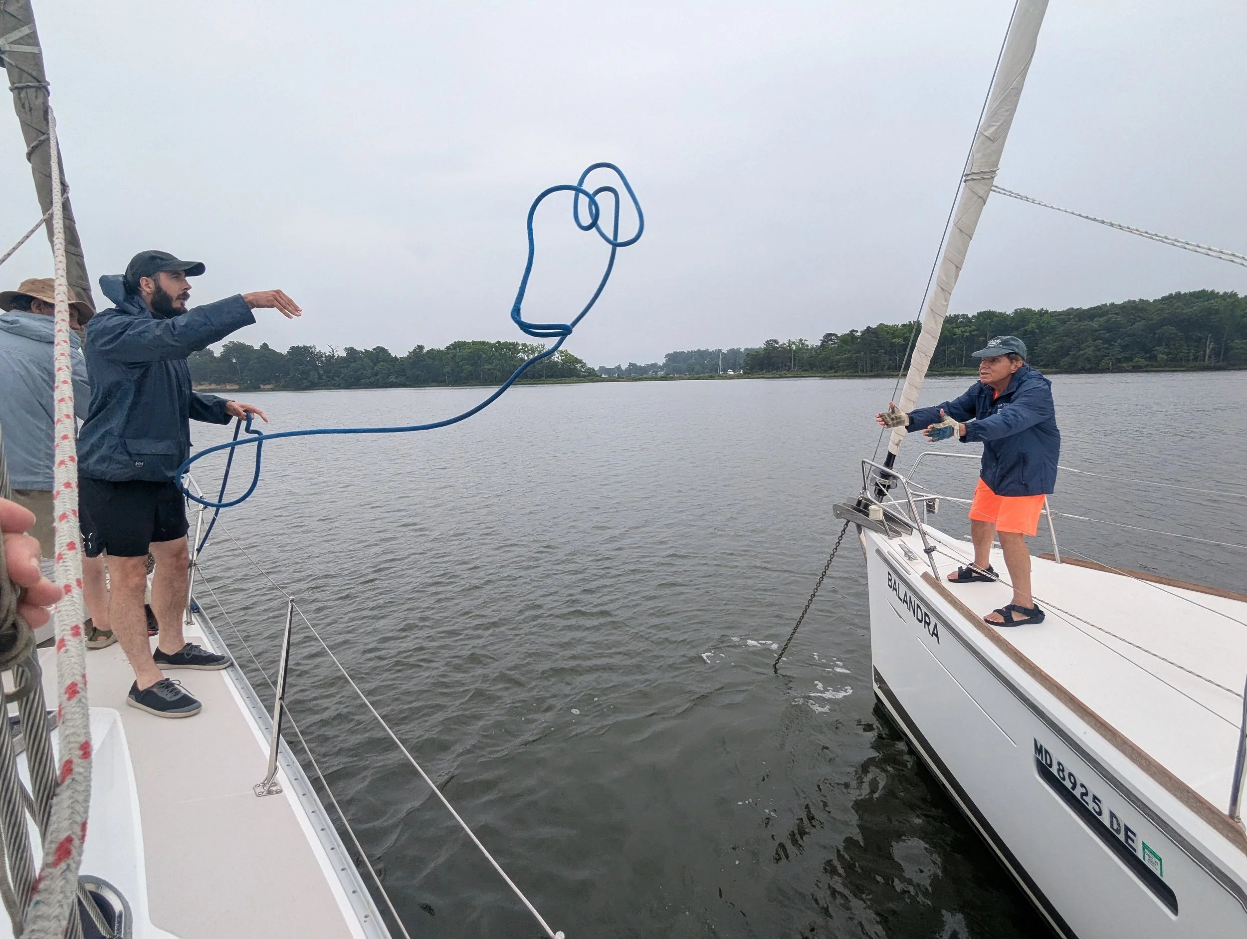 First-time sailor Phil Cornelius tosses a line to OG Club Member John Francischetti during raft-up