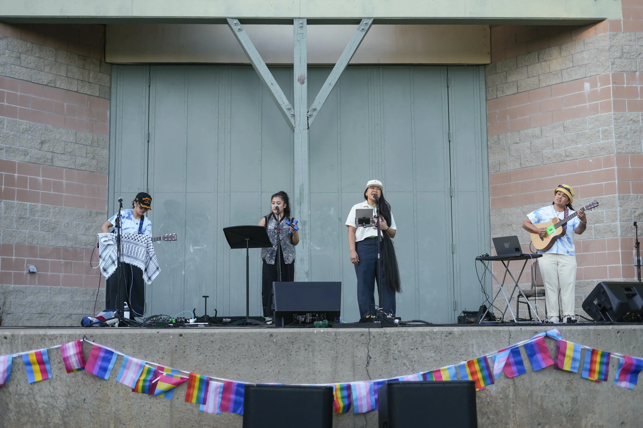 Live band performing on an outdoor stage with professional PA speakers, stage monitors, microphones, and live sound rental services in Sacramento.