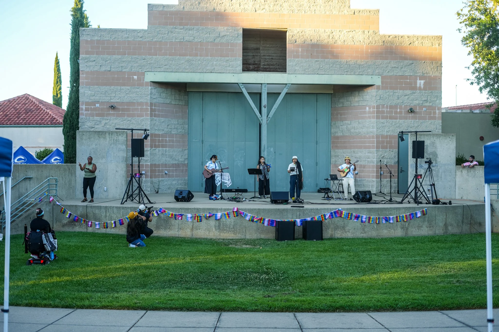 Wide view of a Sacramento community event featuring professional live sound rental, outdoor stage production, PA speakers, microphones, and audience coverage.