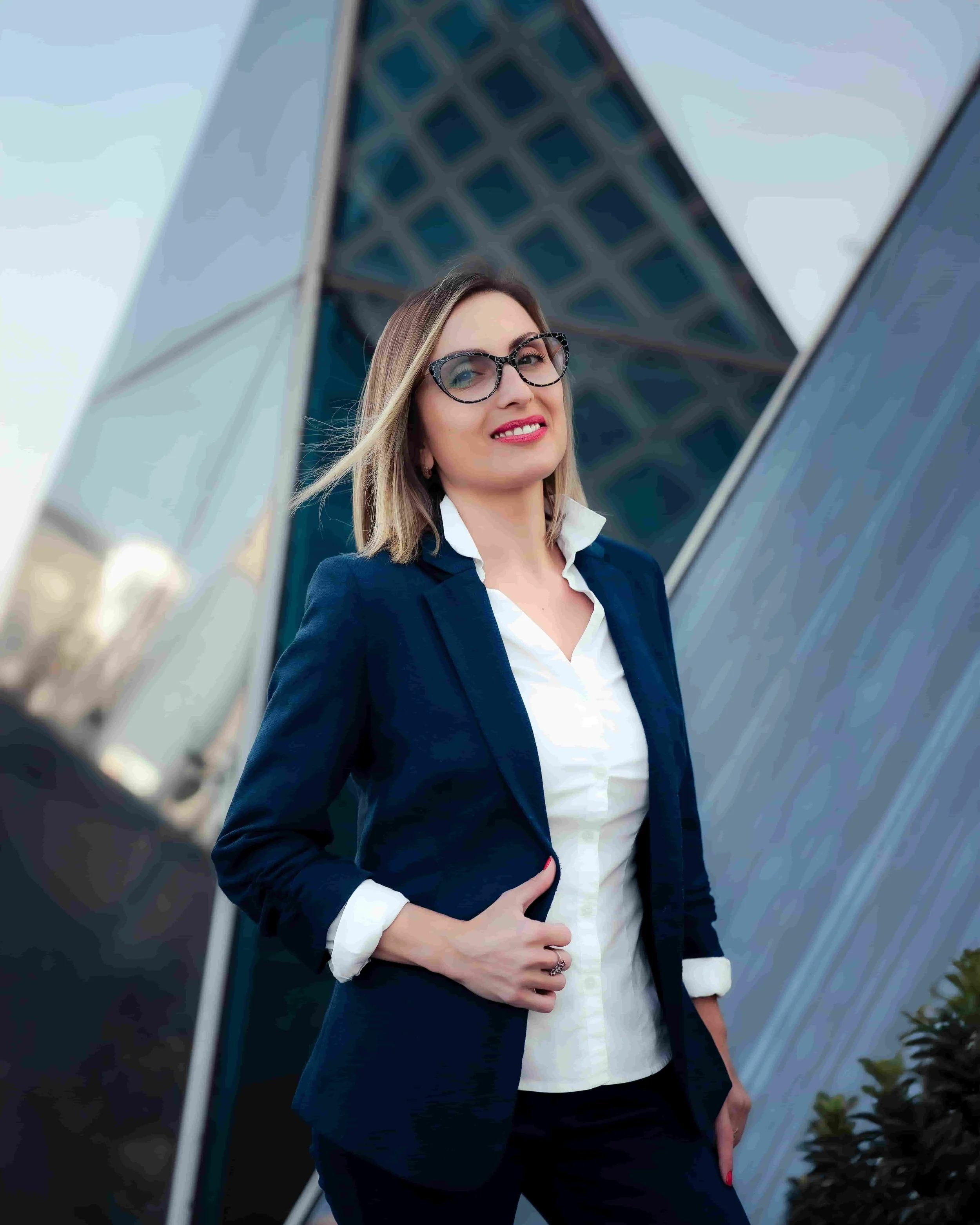 Business coaching for professionals seeking clarity, confidence, and sustainable success, shown by a smiling businesswoman outdoors.