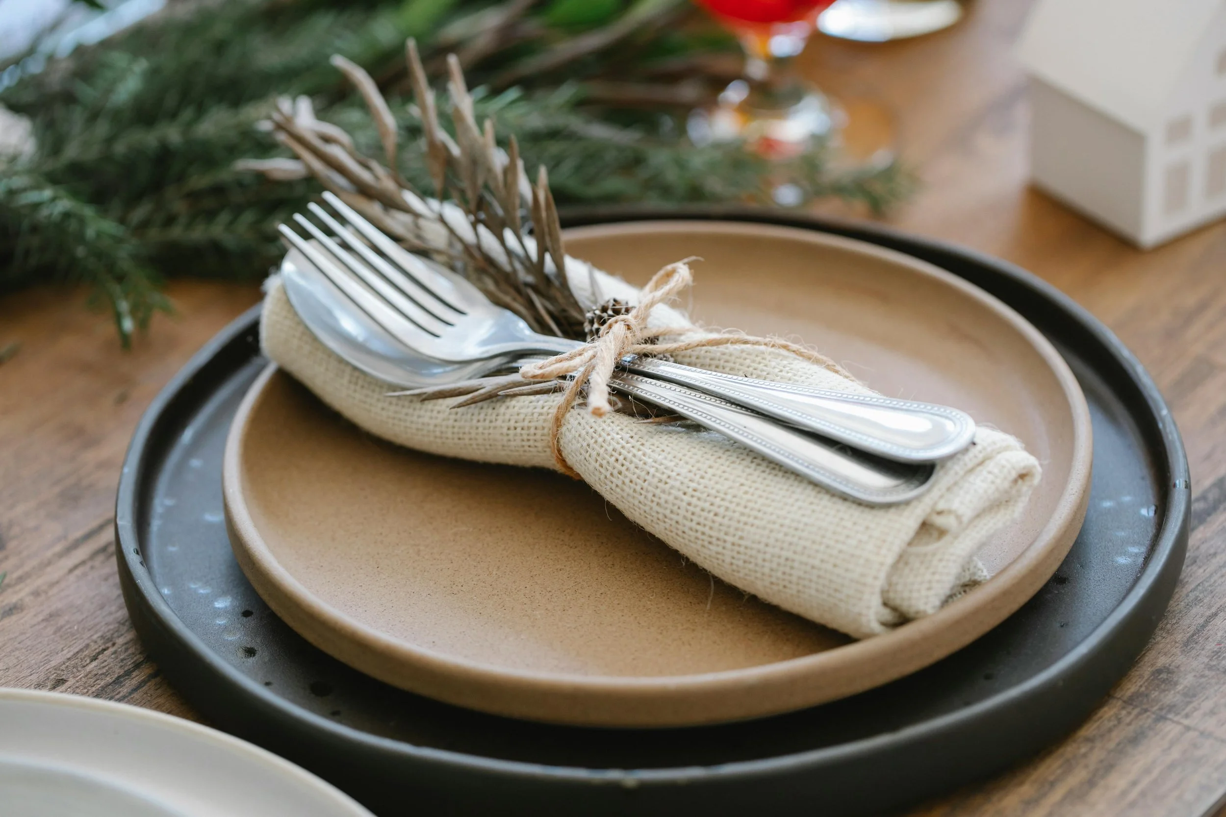Minimal holiday place setting with rustic napkin and silverware, symbolizing peaceful, child-free celebrations during the holiday season.