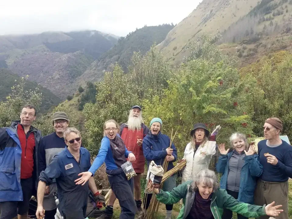 Rameka planting team photo surrounded by green trees and hills in Rameka Forest.