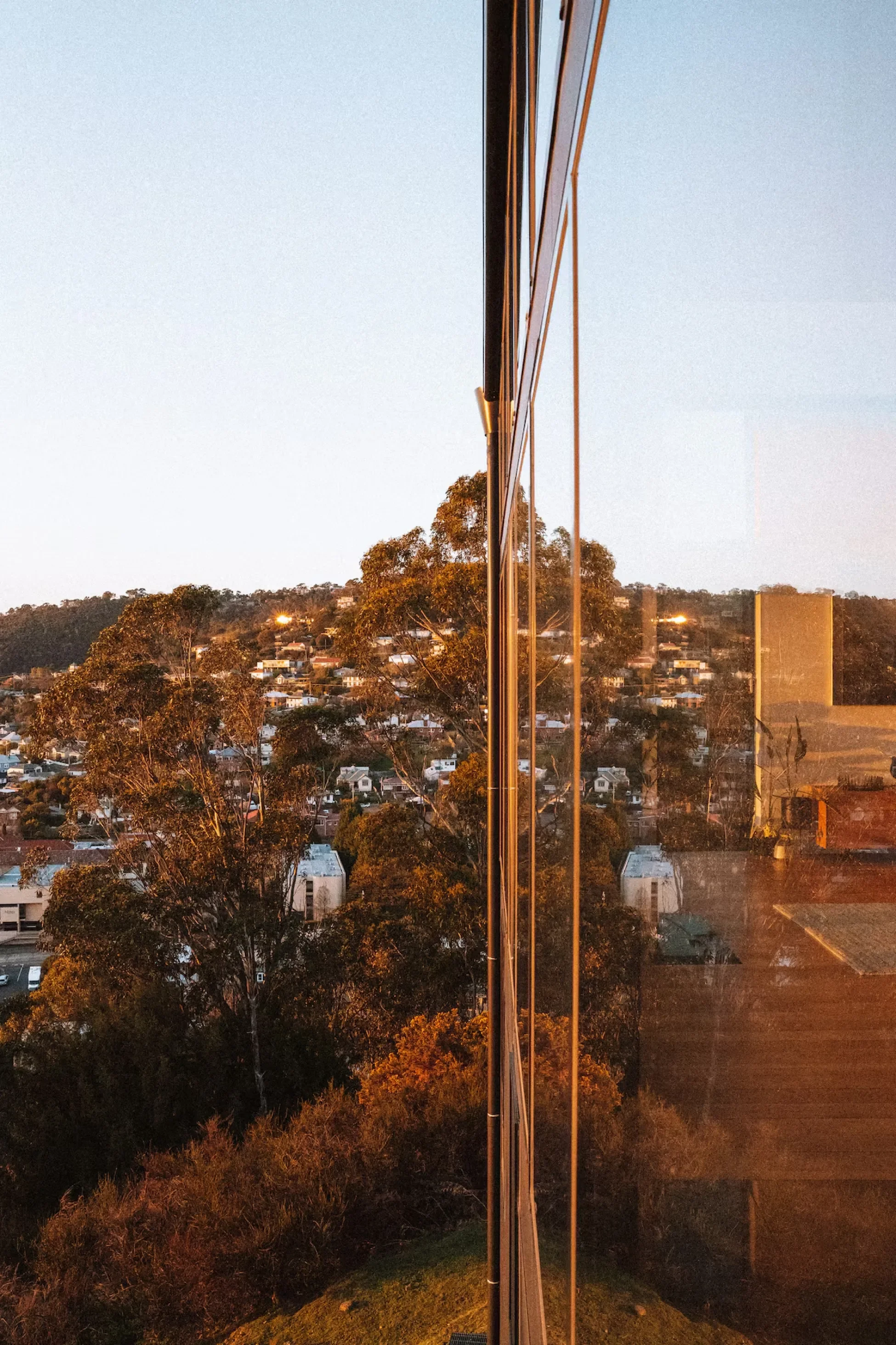 Exterior glass facade of Glass Holme overlooking Hobart at sunset