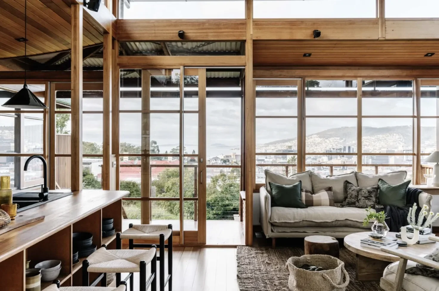 Open plan living room with floor-to-ceiling timber-framed windows overlooking Hobart city and kunanyi Mount Wellington, Japanese-inspired extension Seaview Glebe Tasmania