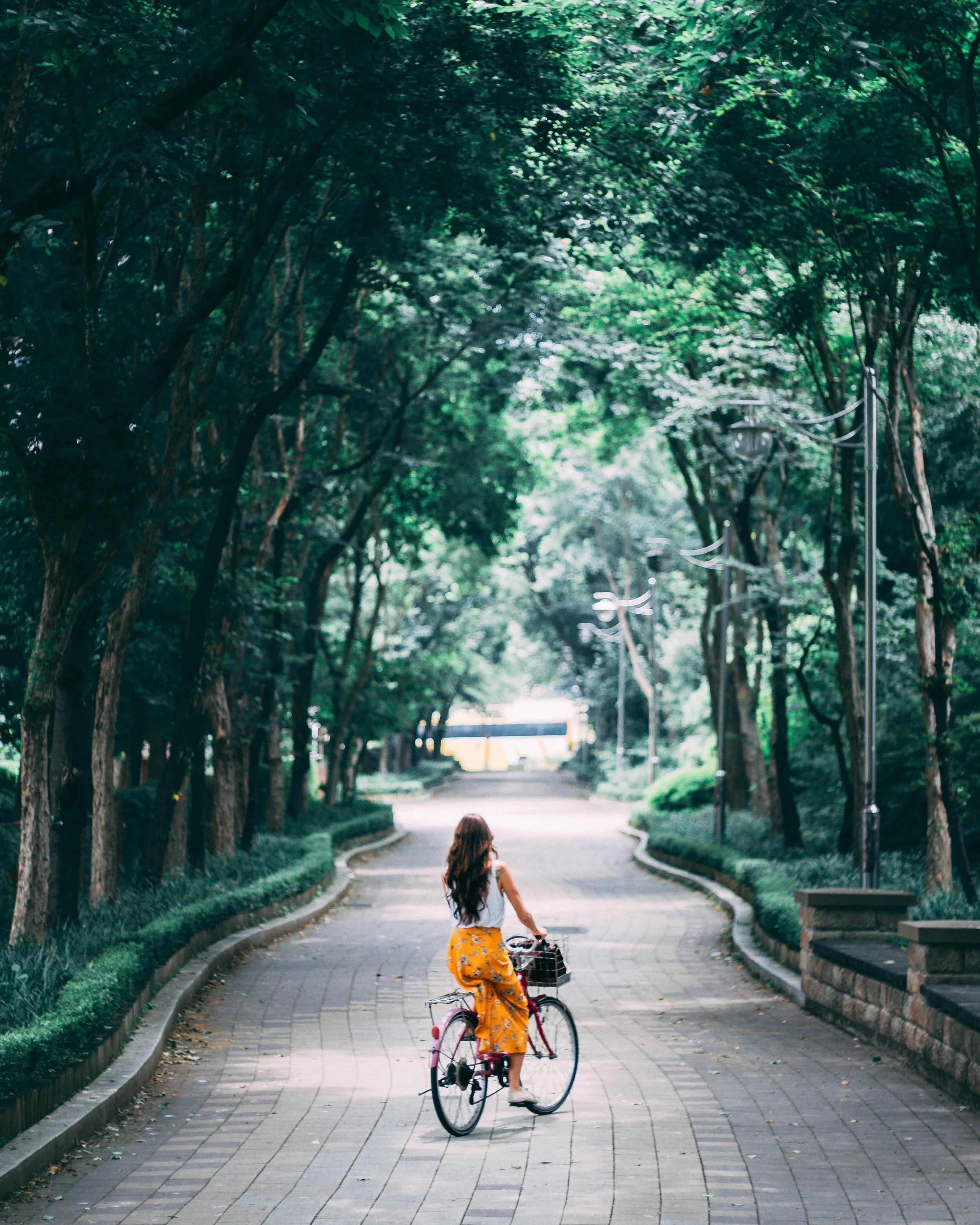 image of woman in a park on a bike wearing a yellow skirt representing the journey of therapy for women with OCD in sacramento
