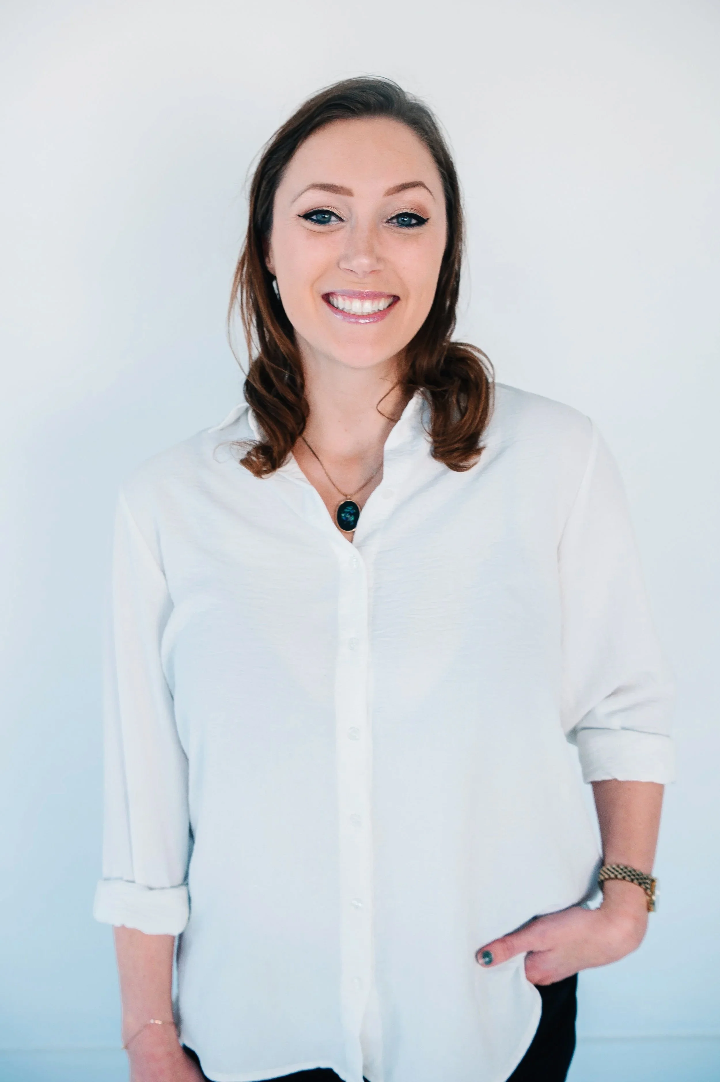 Black and white portrait of a woman with long, wavy hair, wearing hoop earrings, a striped shirt, and smiling.