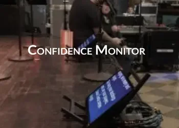 A person working in a service counter area with a screen labeled 'Confidence Monitor' in front of them.