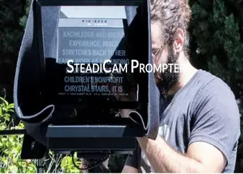Person operating a professional camera outdoors, with a monitor displaying text called steadicam