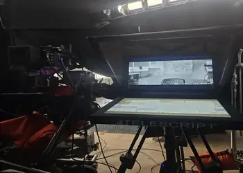 Behind the scenes of animation or film production, showing a computer monitor, editing software, and filming equipment. PTZ prompter