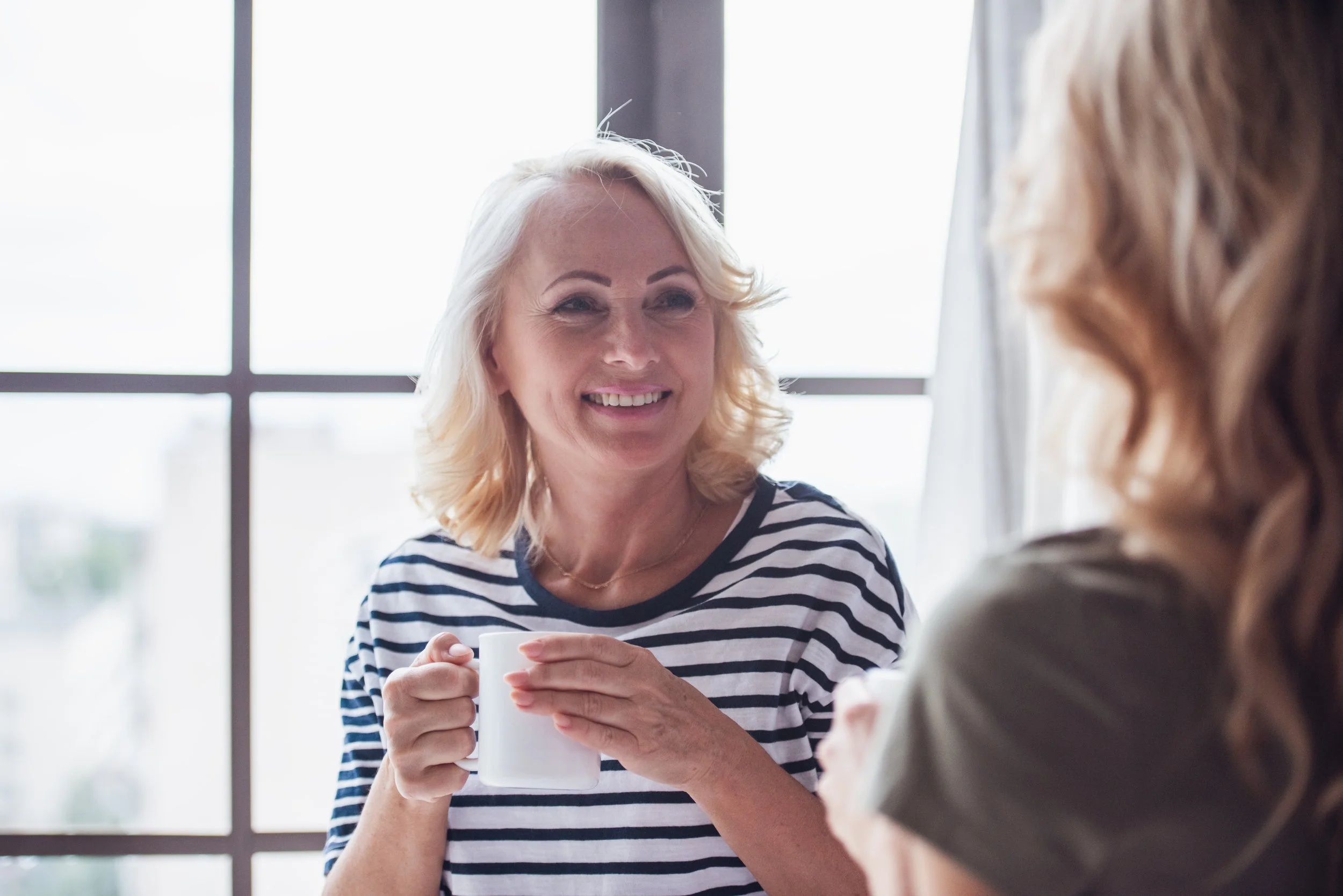 two-women-chatting-over-coffee-by-window-2026-09-21-02-03-04-utc.jpg