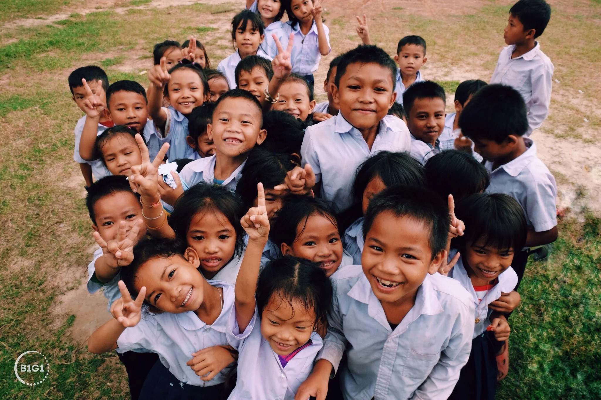 a group of children in school uniforms smiling at the camera