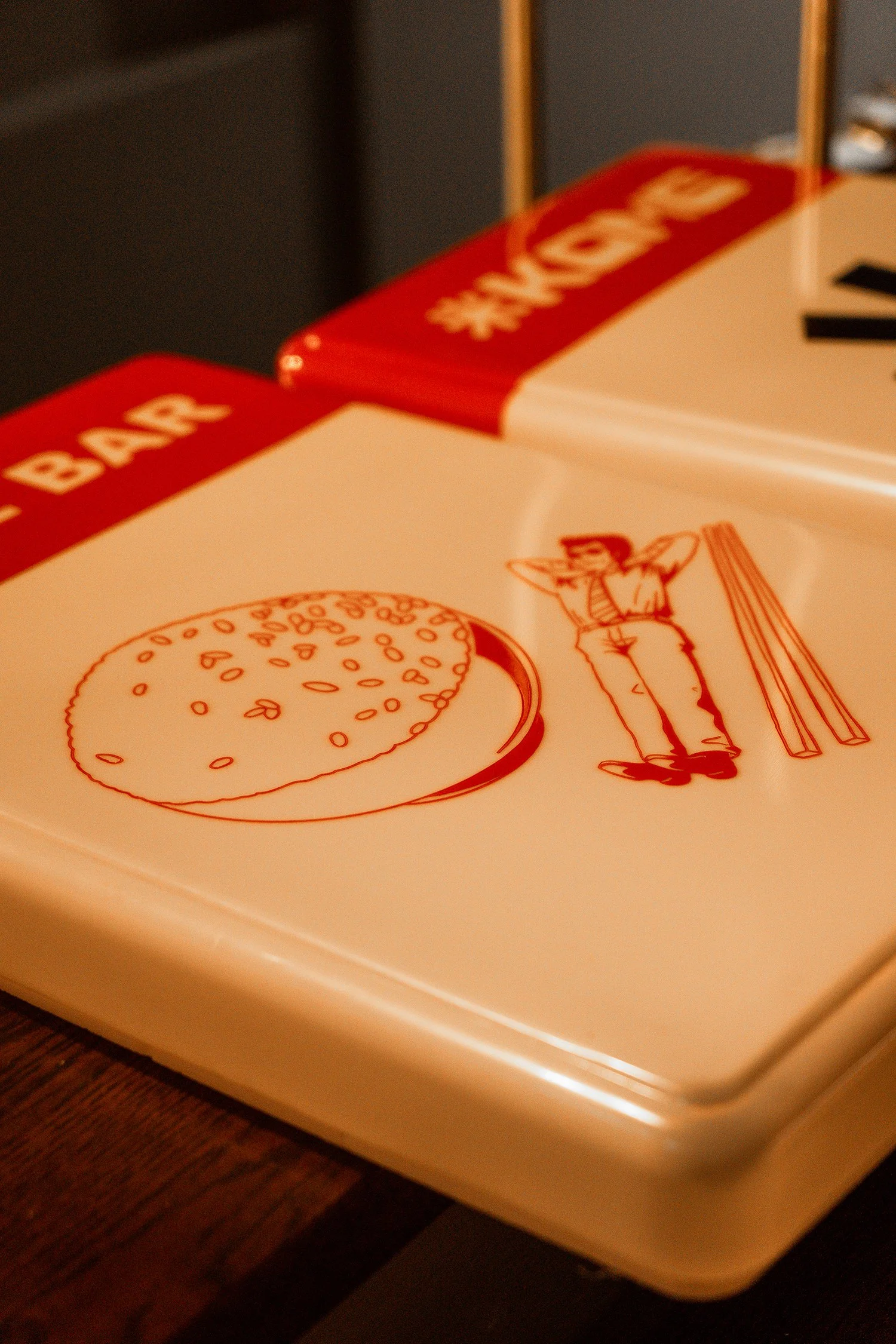 Vintage burger restaurant menu with an illustration of a burger, a person, and chopsticks.
