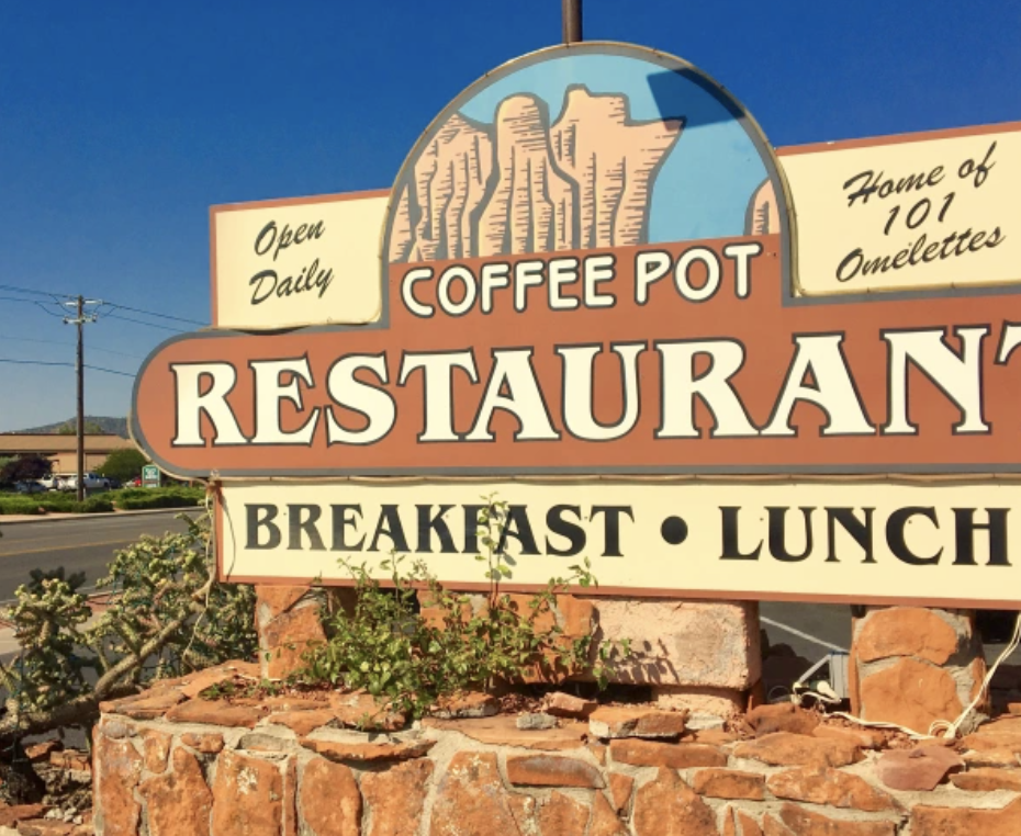 Sign for Coffee Pot Restaurant with a mountain graphic, indicating it is open daily and known for 101 omelettes. Offers breakfast and lunch.