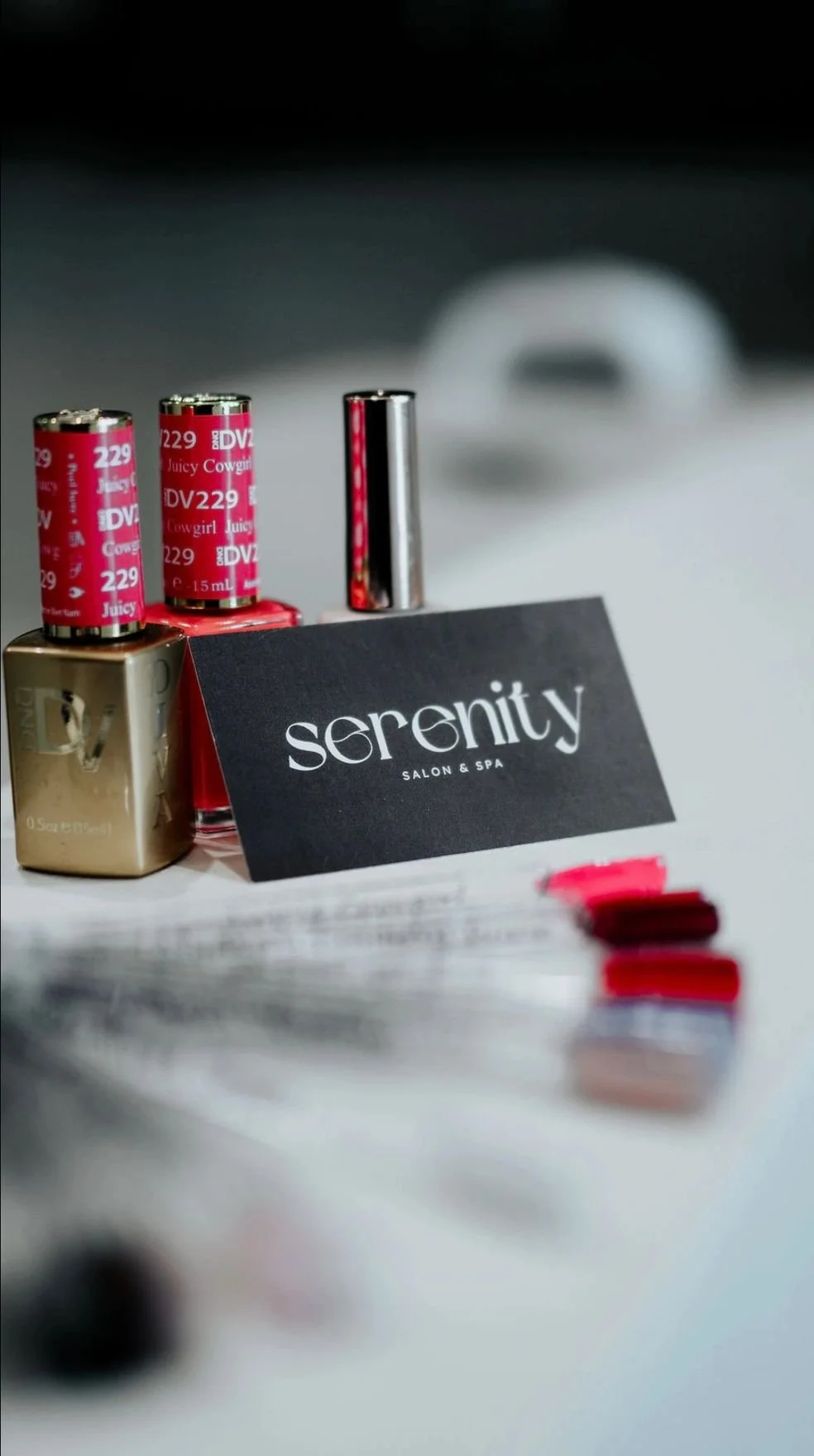 Nail polish bottles and color swatches on a table at Serenity Salon & Spa