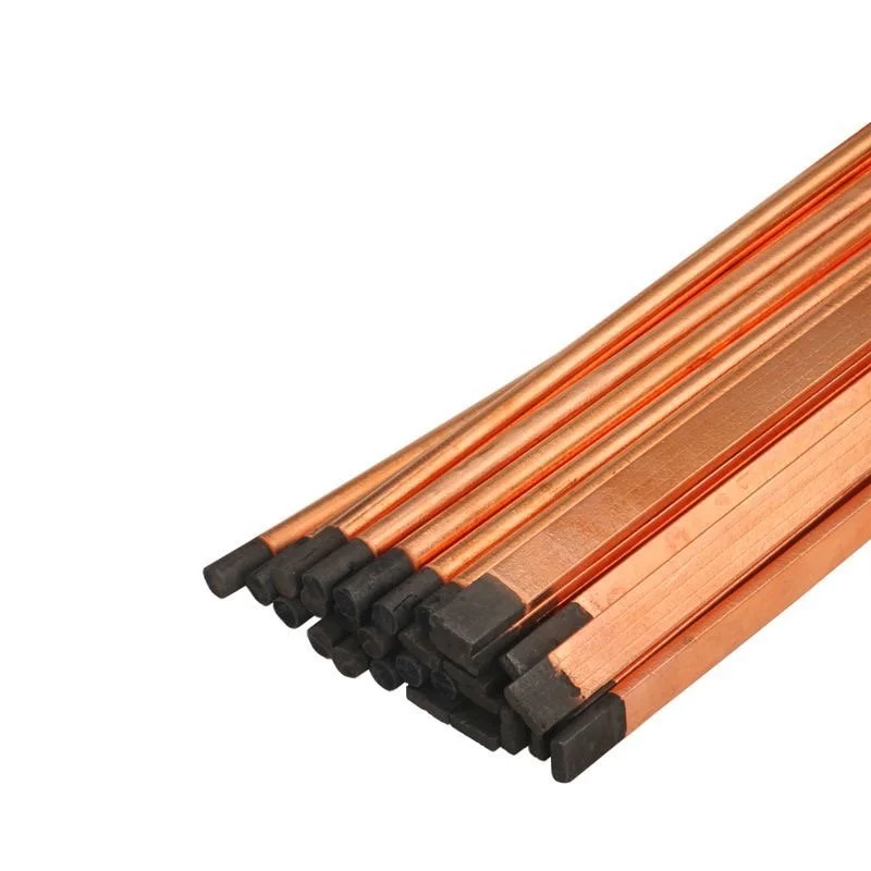 Set of copper welding rods with black tips stacked together.