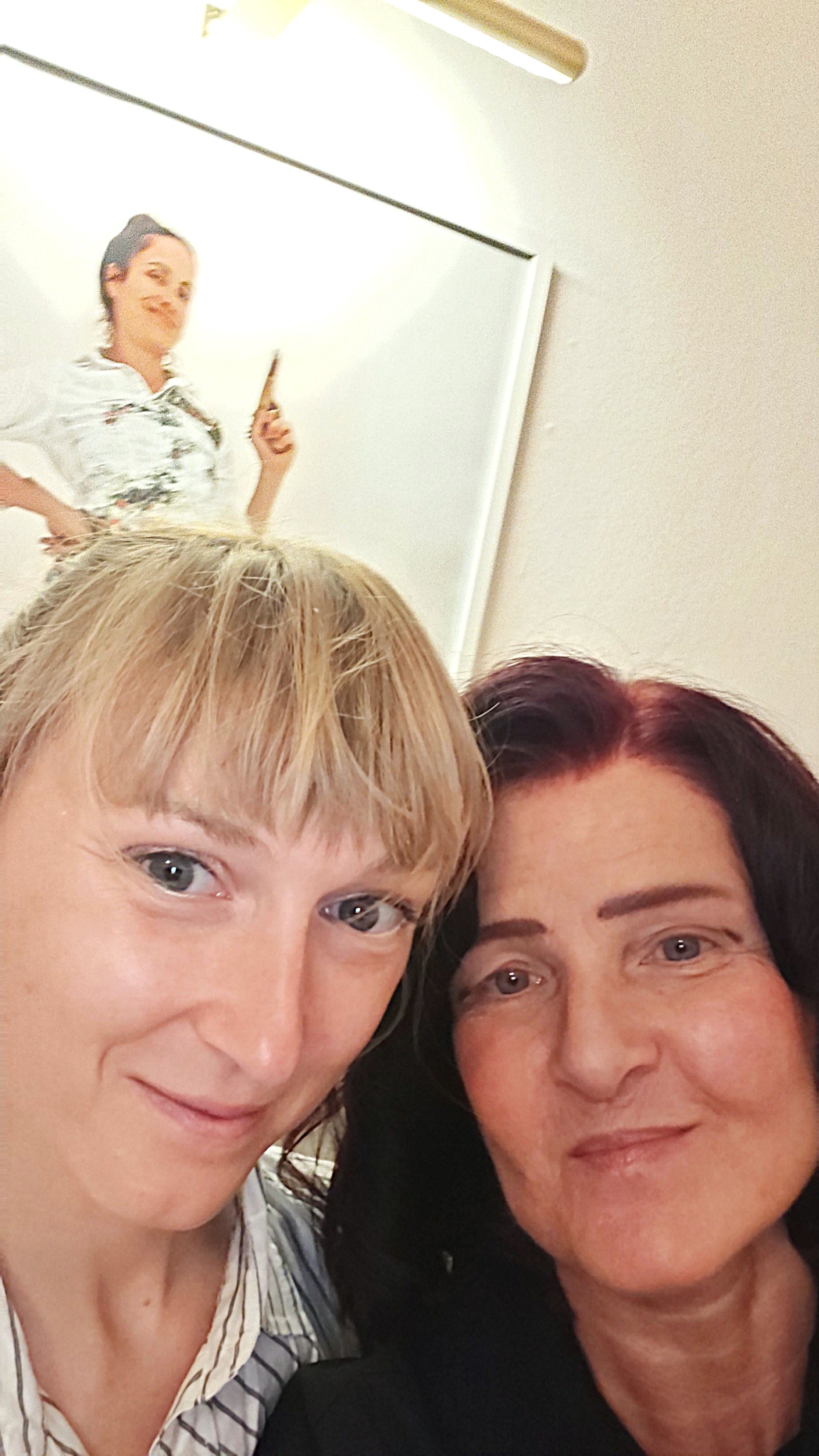 Ein Gruppenfoto von zwei Frauen, die sich nah beieinander lachen, mit einem weißen Hintergrund und einem oberen Bild eines anderen Mädchens, das auf einem Whiteboard steht und mit einem Zeigestock in der Hand posiert.