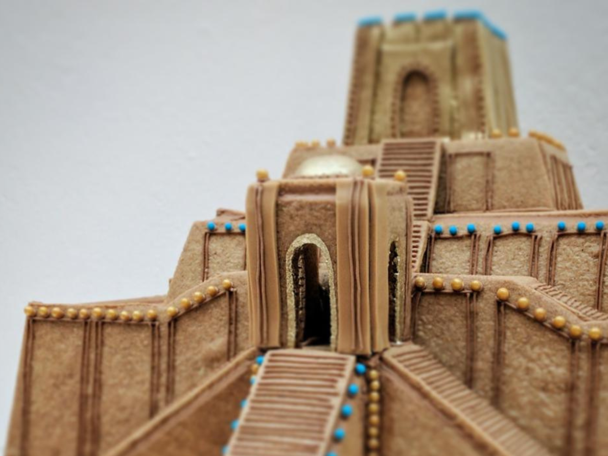 Detailed gingerbread monument of the Ziggurat of Ur, decorated with colorful icing and small candy beads.
