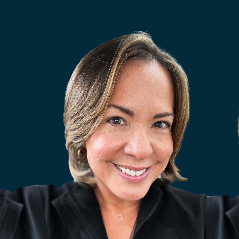 A woman smiling and taking a selfie against a dark teal background.