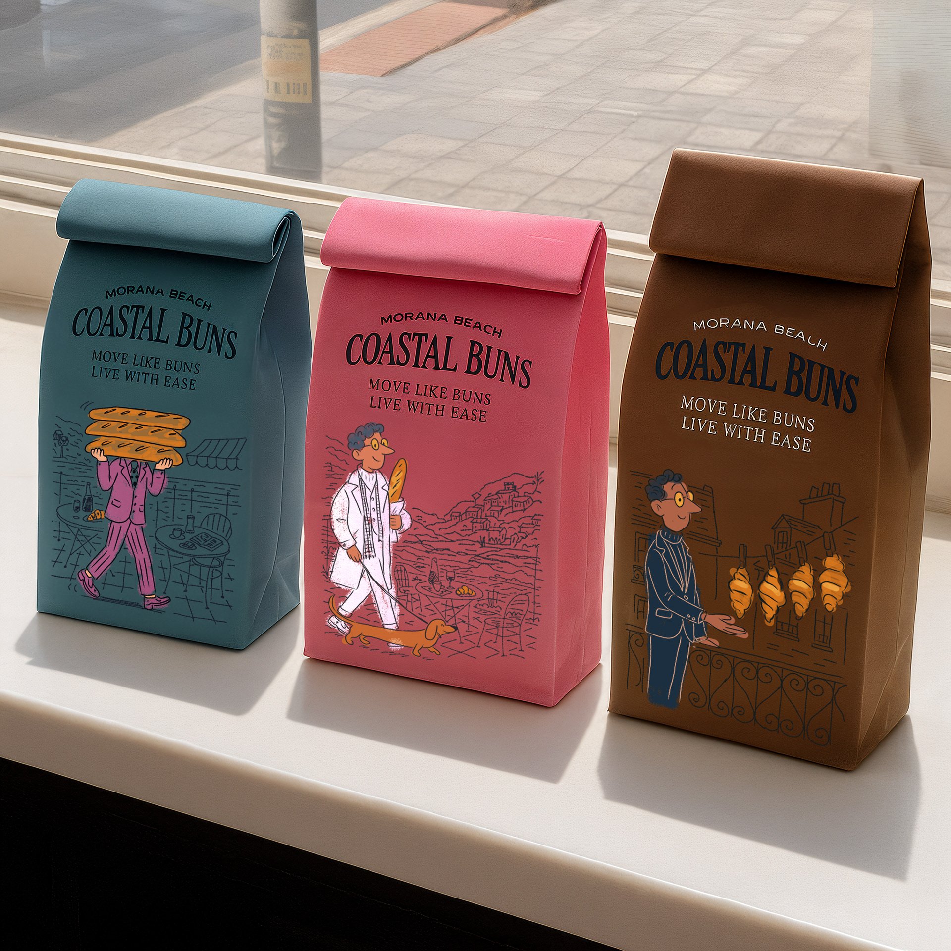 Three paper bags in blue, pink, and brown with illustrated bakery theme and the words "Morana Beach Coastal Buns" and "Move Like Buns Live with Ease" printed on them, positioned on a white windowsill with a window and exterior sidewalk in the background.