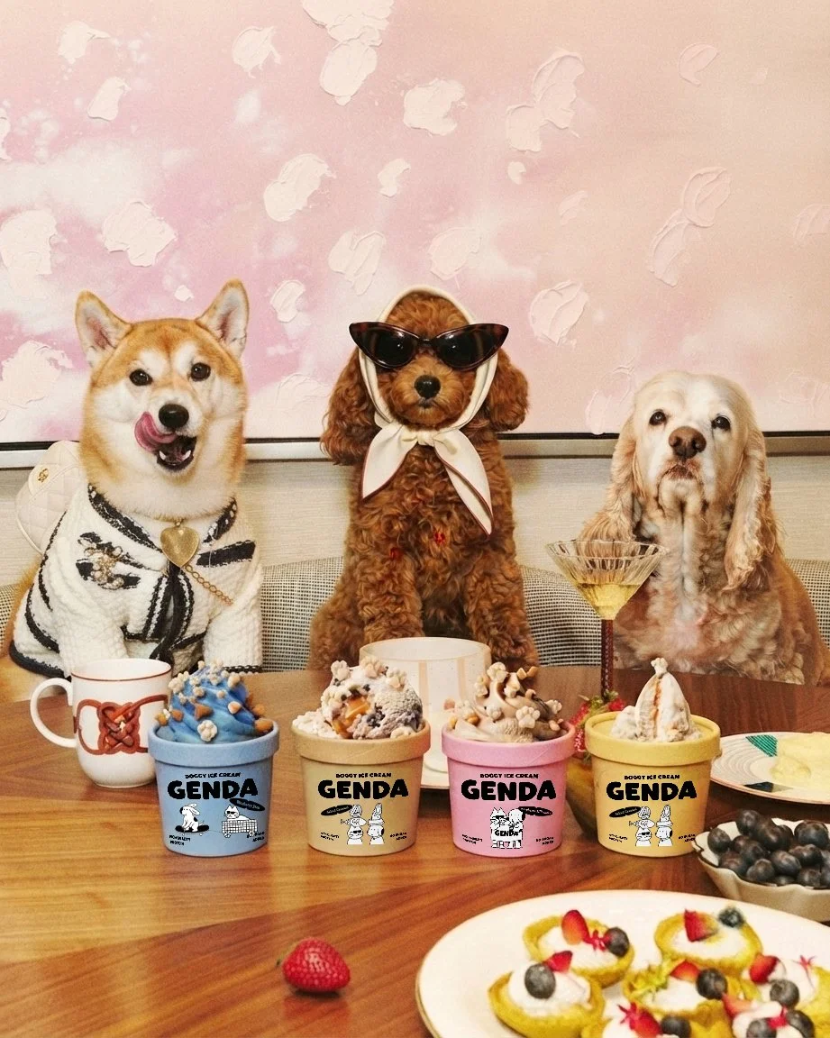 Three dogs dressed up with ice cream and dessert on a table, with a pink background with white pattern.