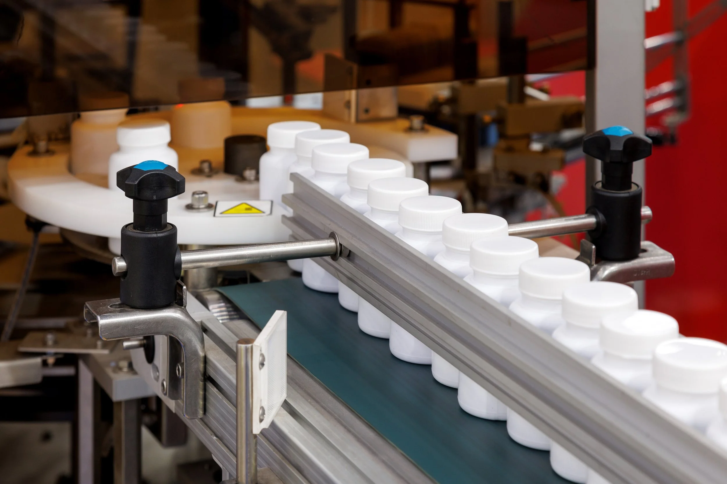 Bottles of medicine traveling down a conveyor in healthcare industry warehouse.