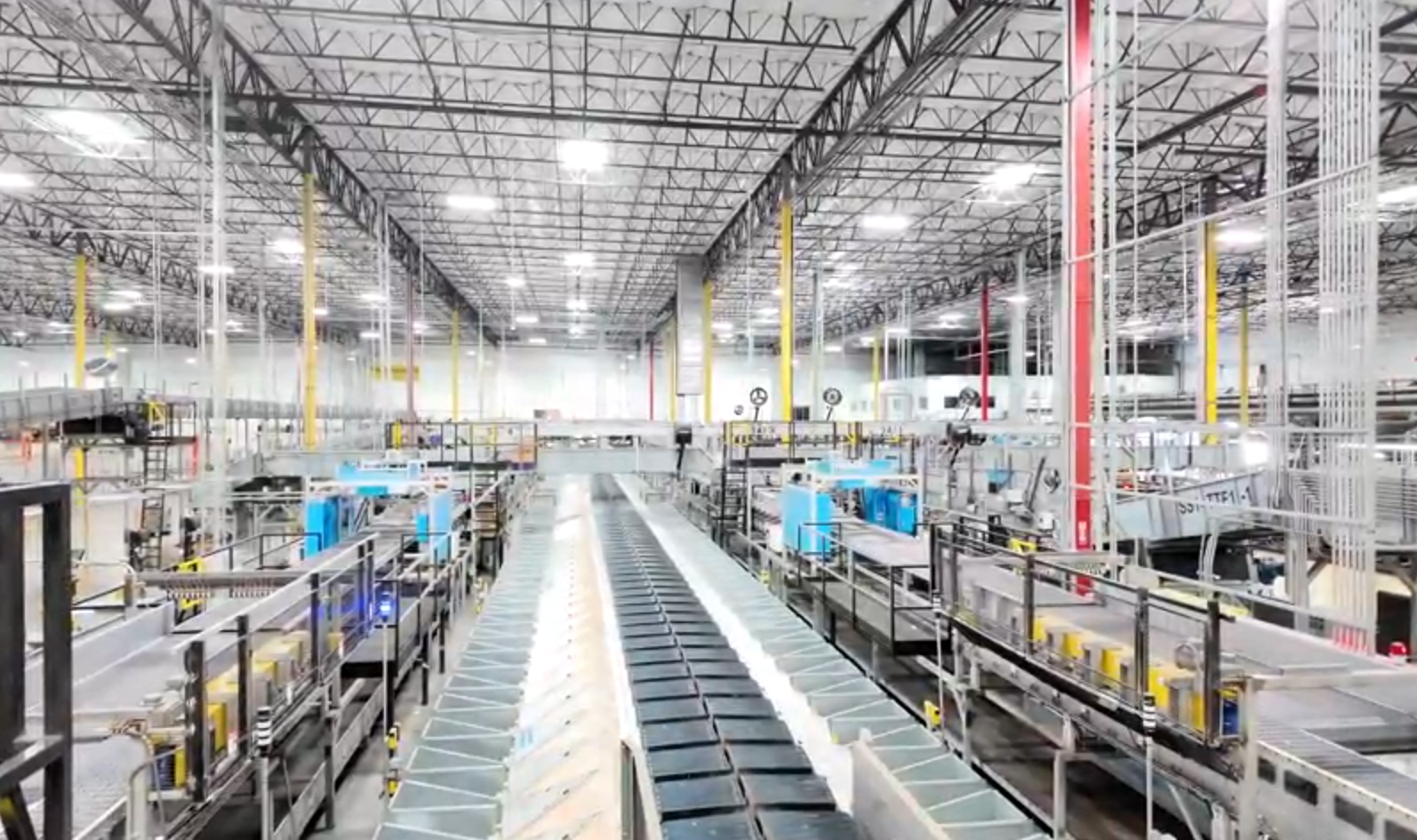 Aegis Automated Smalls Bagging (ASB) system wide shot in a parcel facility, showing sorters, SmartBins, and end to end automation process.