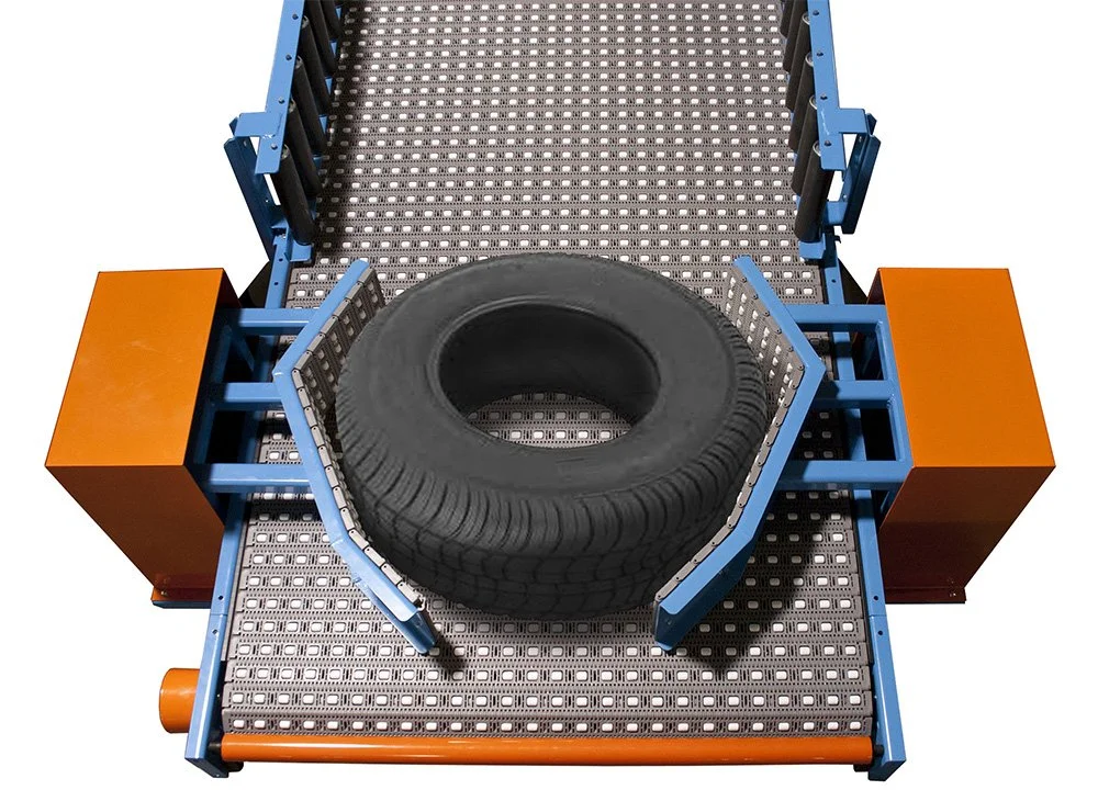 Wheel and tire conveyor with tire shown on the conveyor being moved with gray conveyor belt and orange and blue components.