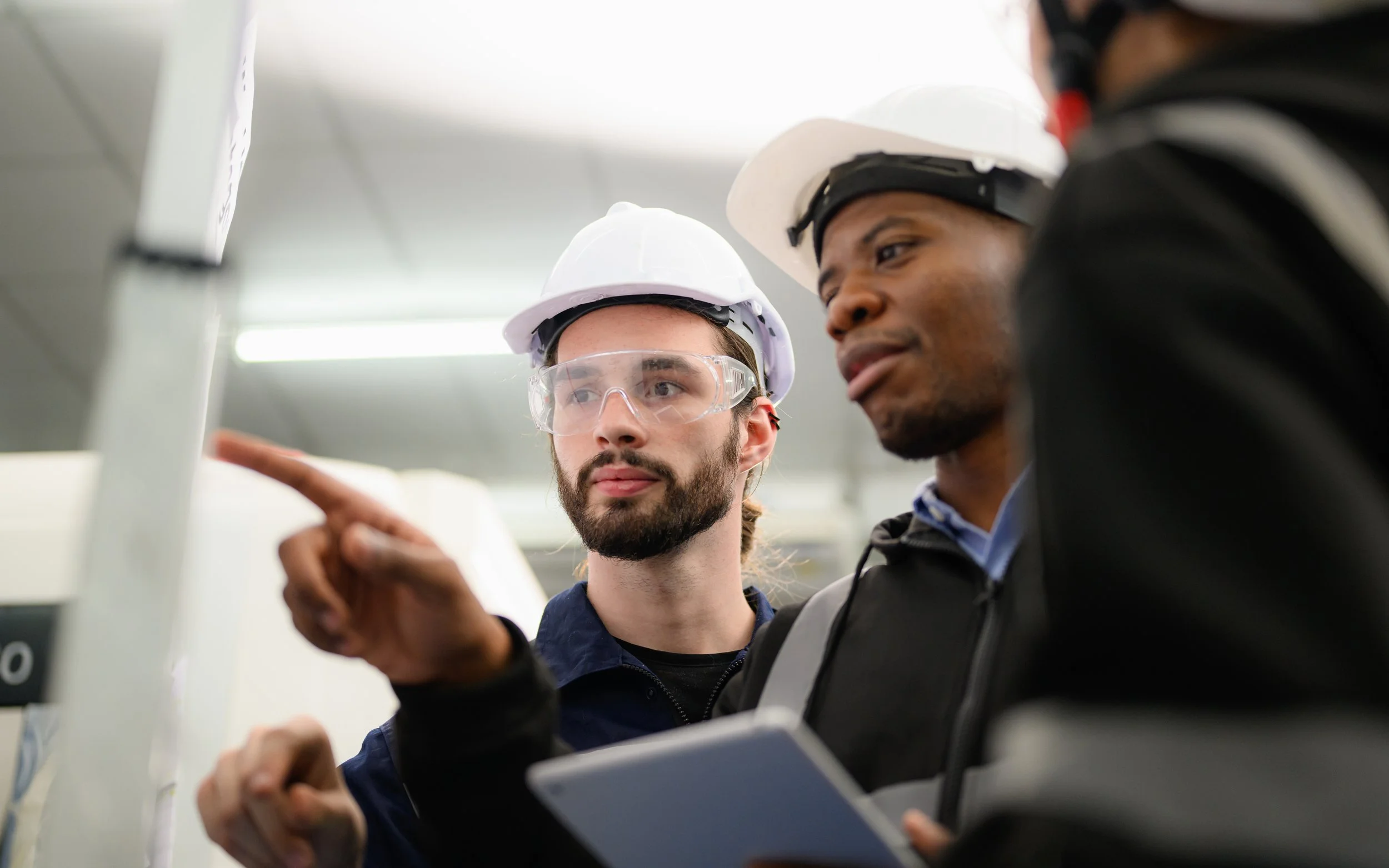 Engineers reviewing technical training on a whiteboard at a distribution and parcel facility.