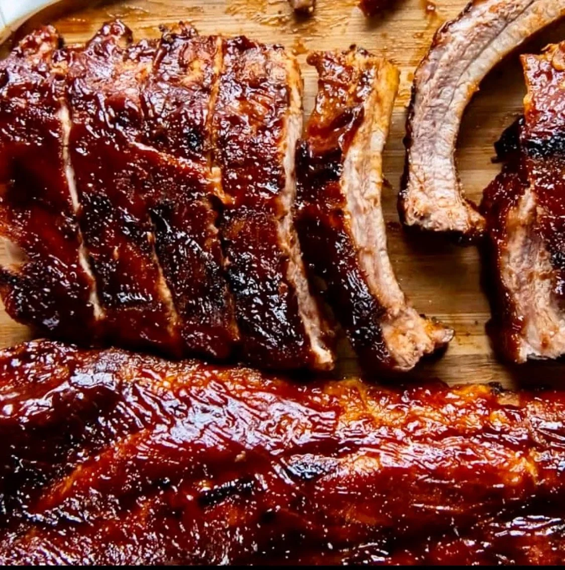 Close-up of barbecued ribs on a wooden cutting board
