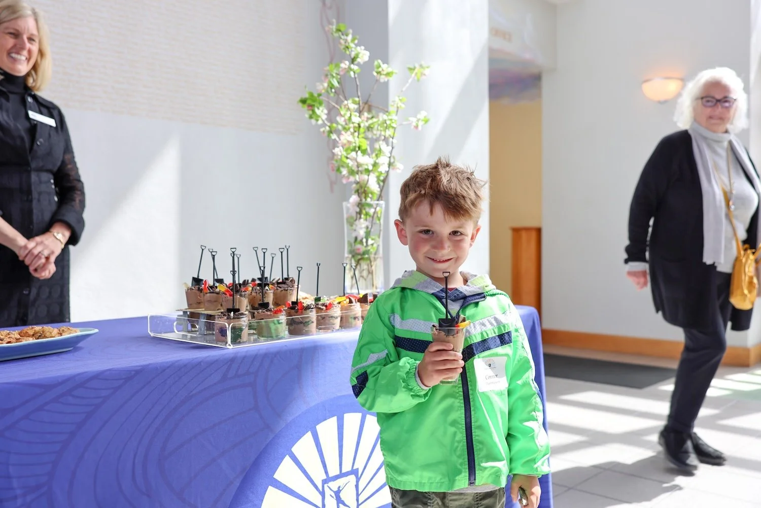 Conner Dannhausen, Gibraltar kindergarten student and son of Myles Dannhausen who attended the auditorium's groundbreaking 35 years ago, enjoys his dirt dessert made by
Duska Pearson, Construction Task Force Chair(left).
