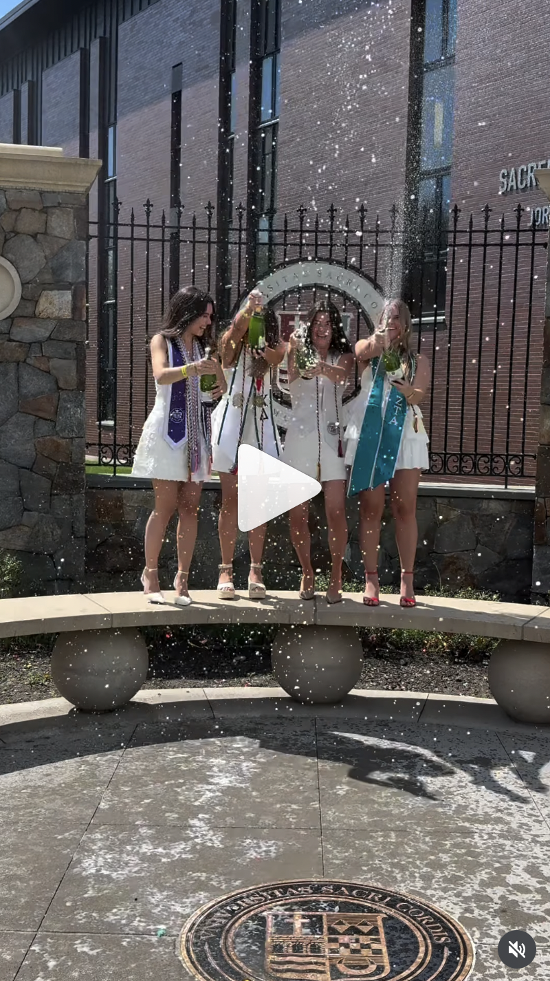 group of seniors in sacred heart university celebrating the graduation taking Champagne photos