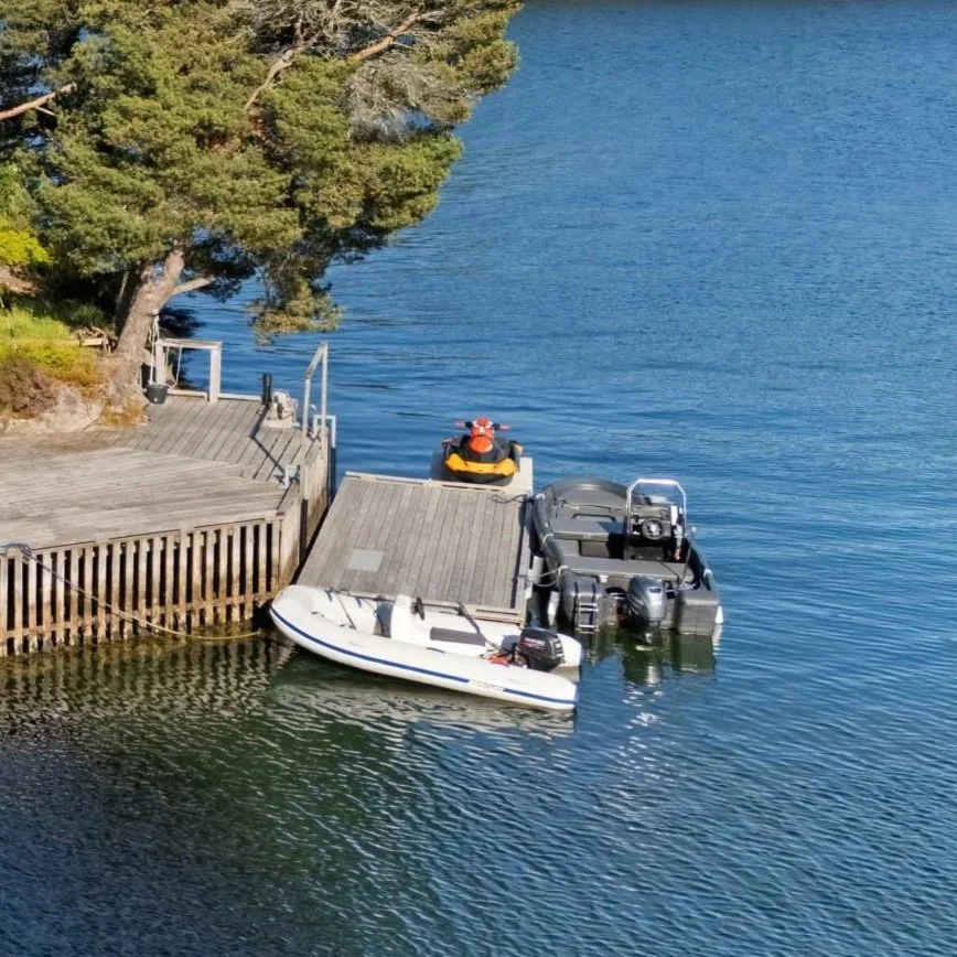 to båter og en vannscooter festet til flytebrygge
