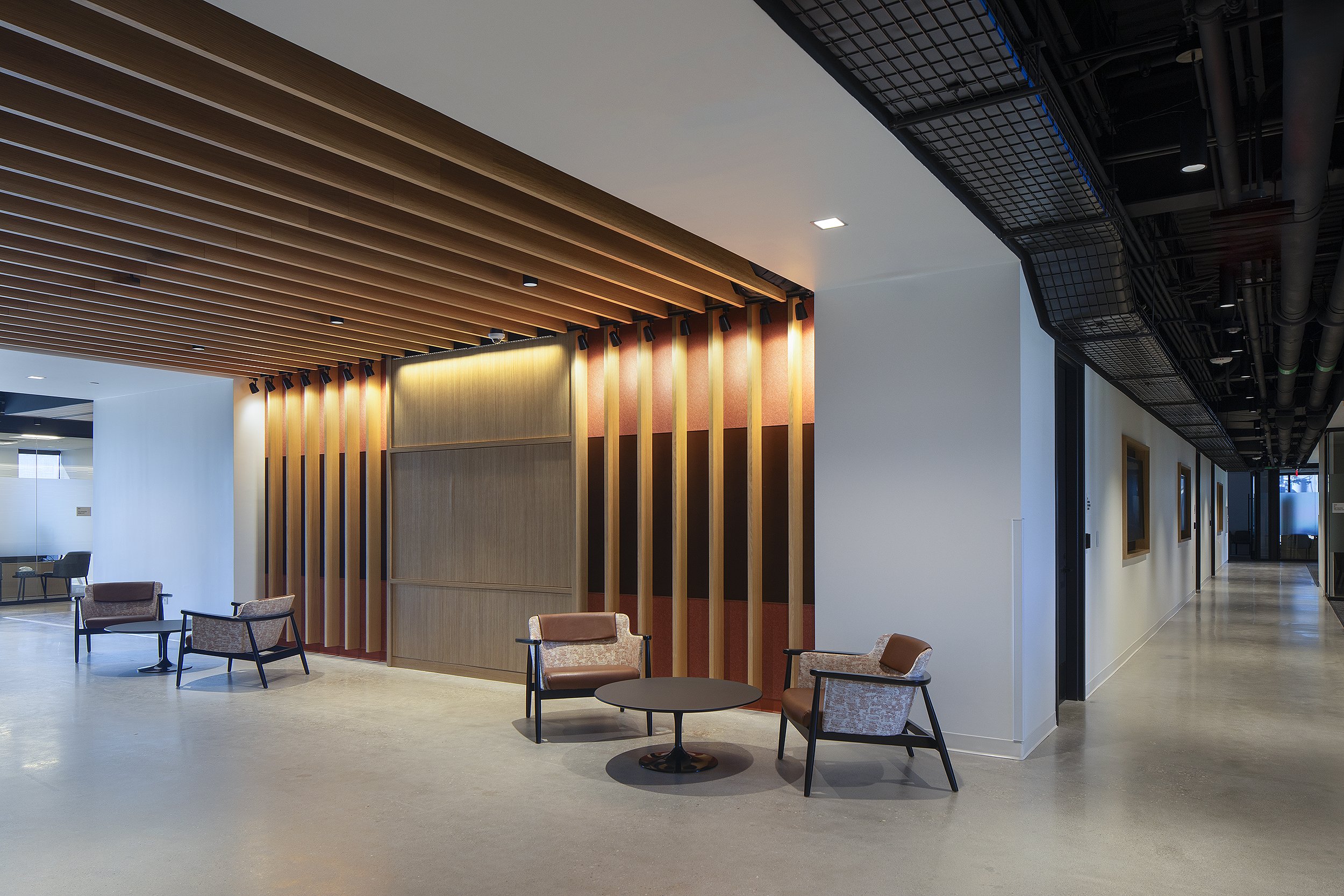 Office work space hall way with seating area two tables with two chairs each