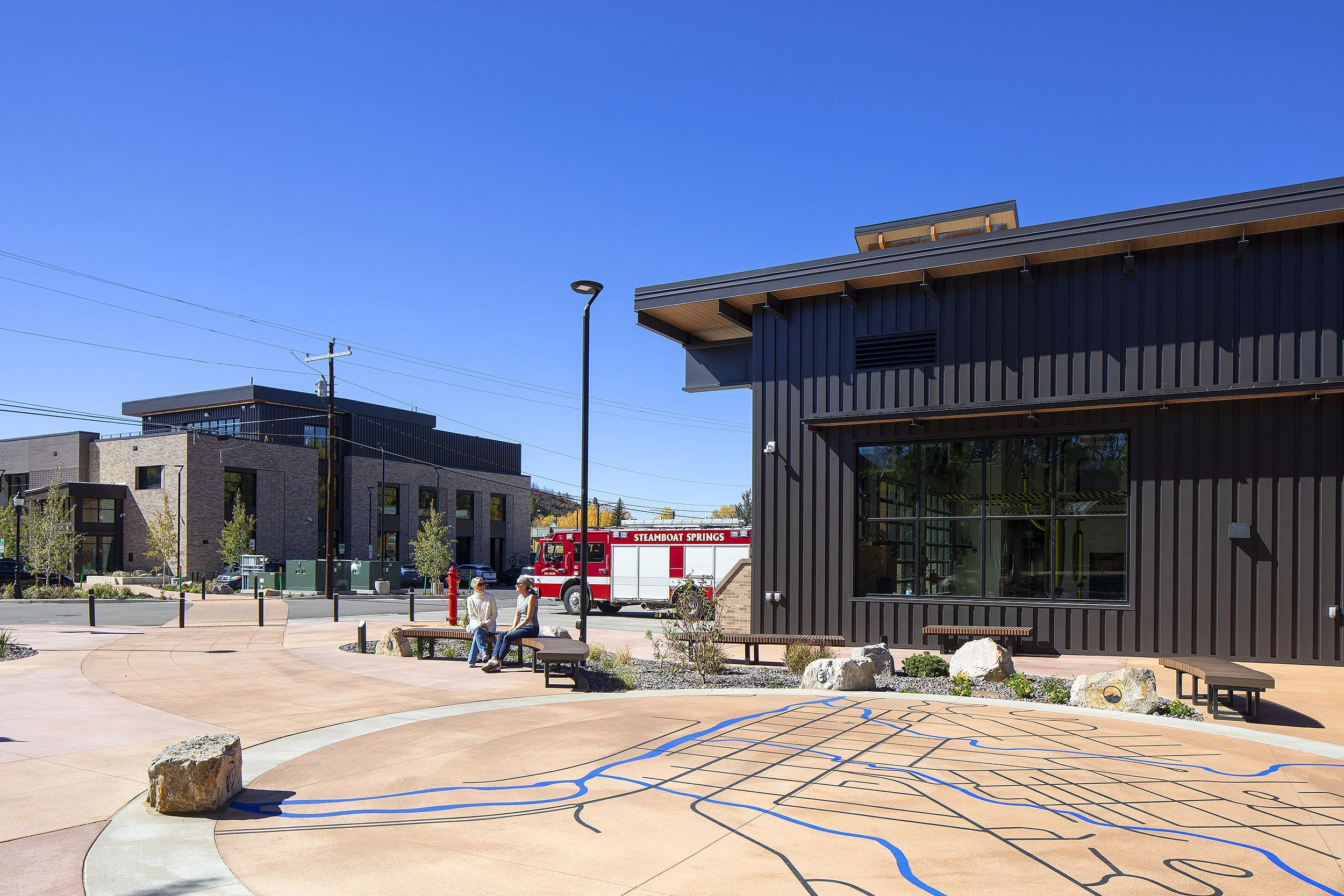 Two women sitting on a bench talking outside of the Steamboat Springs fire station in Colorado 