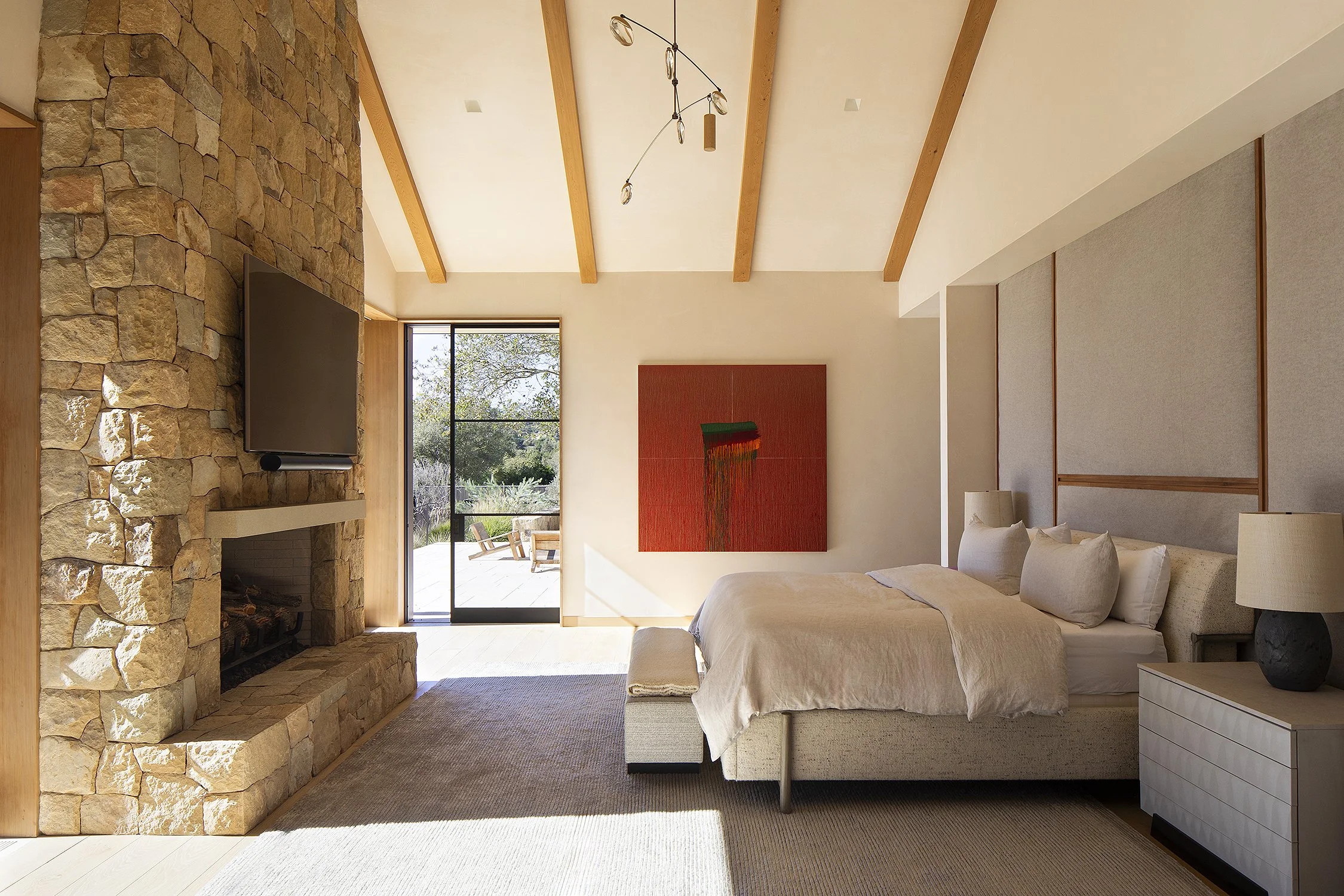 Wonderful natural light spilling into this master bedroom with red art on the wall in this Montecito California home