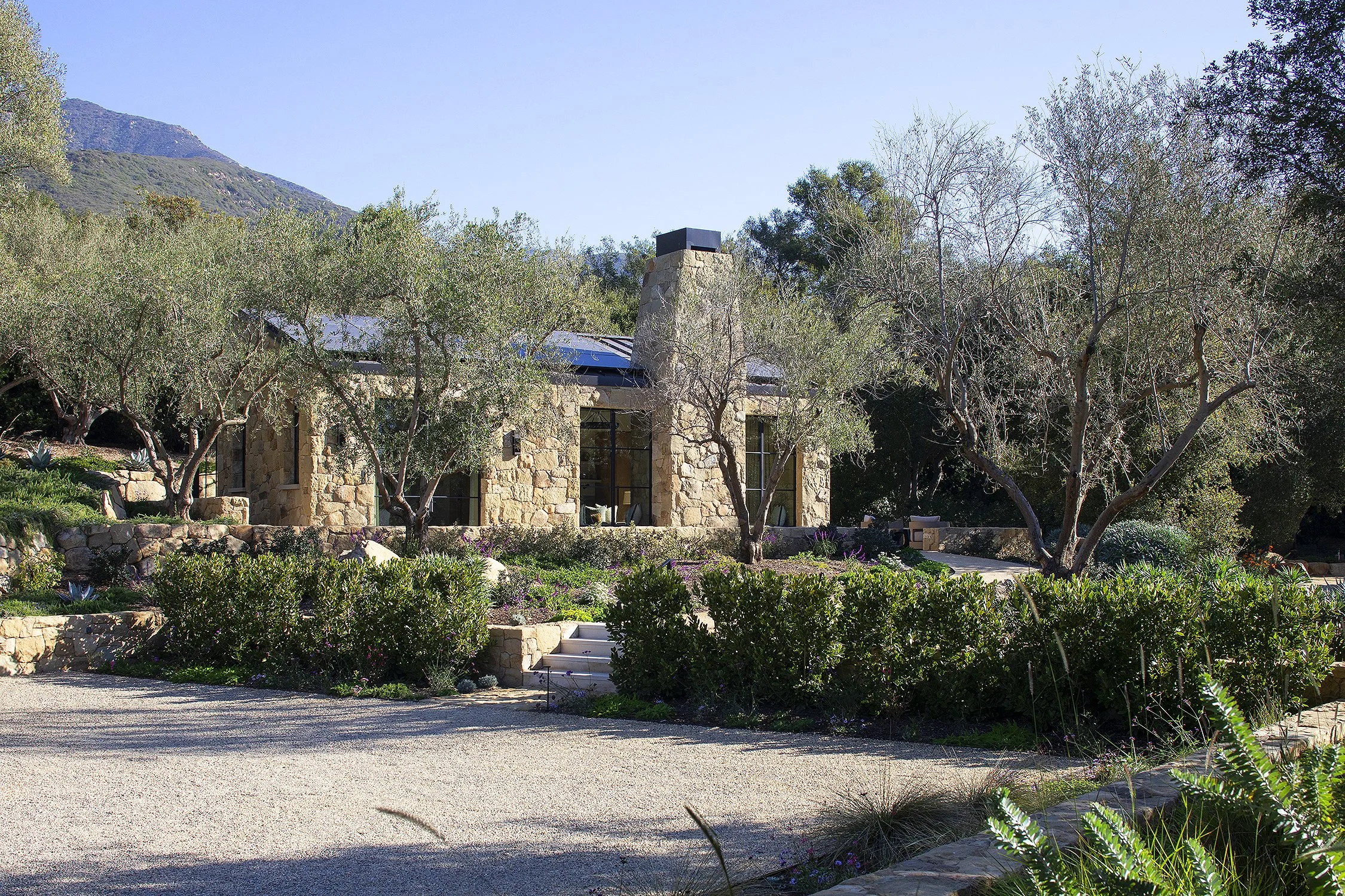 Stone facade of a guest house in lush garden in a Montecito home 