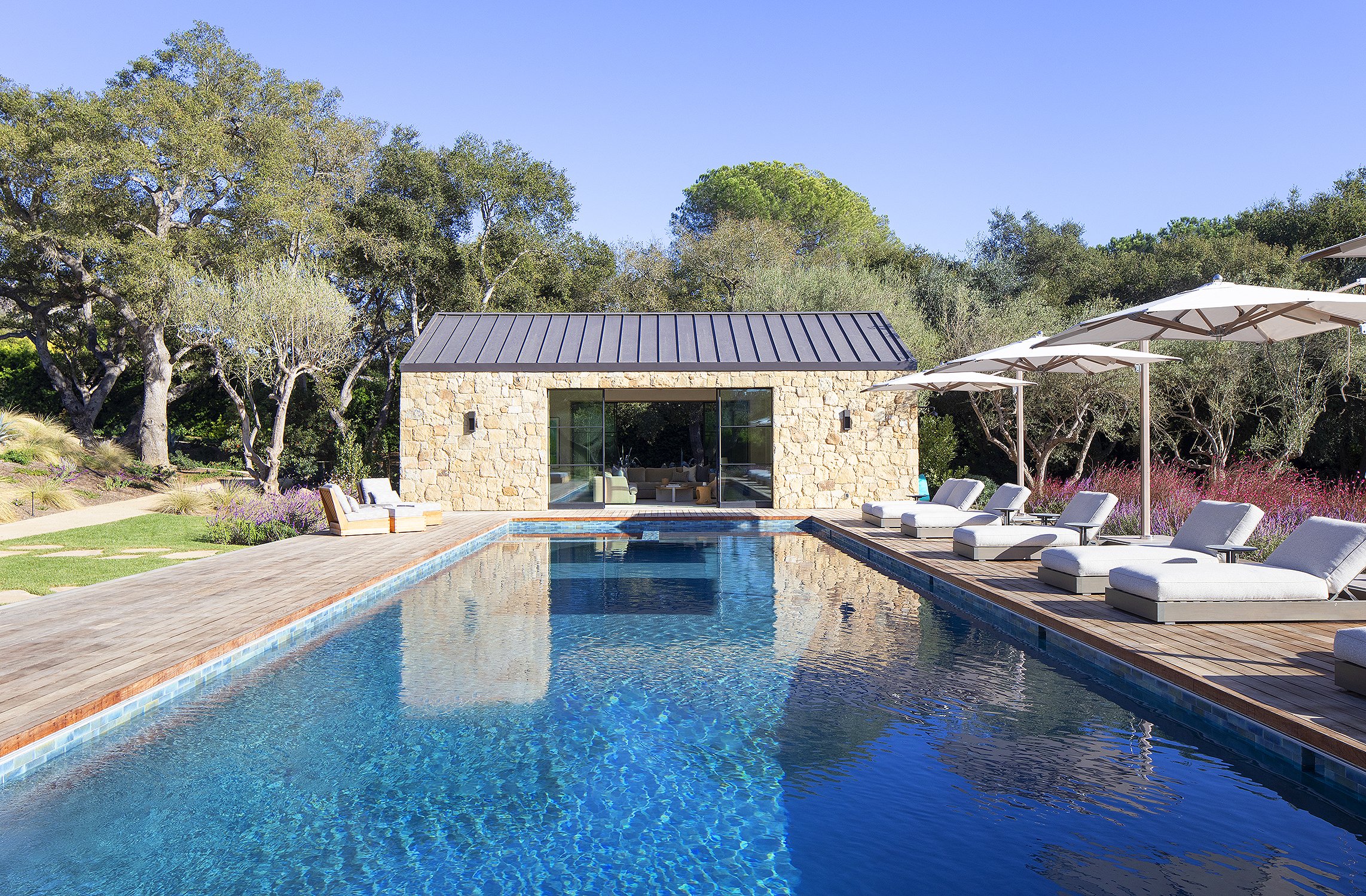 Overlooking pool view of pool room and white umbrellas and chairs around pool