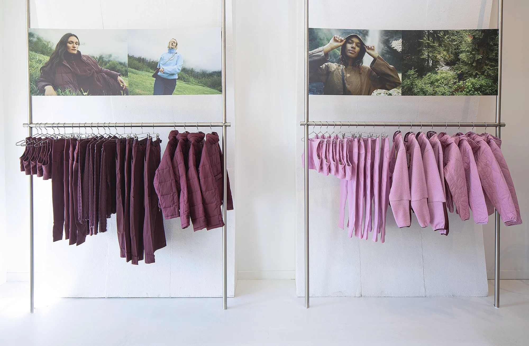 Pink and maroon clothes displayed on rack with graphics above 