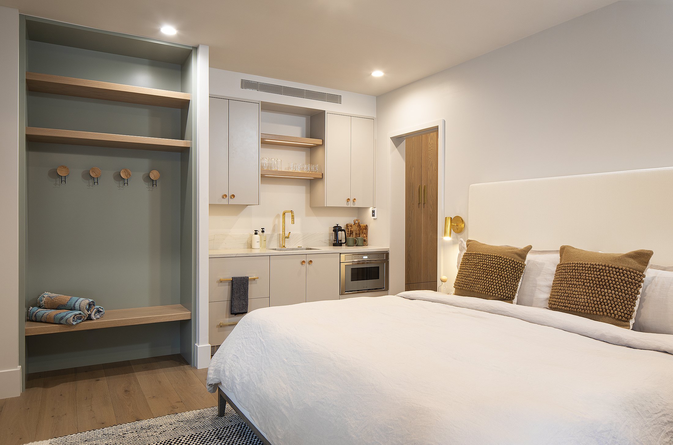 Bed and kitchenette with two brown pillow in a boutique hotel in Crested Butte, Colorado 