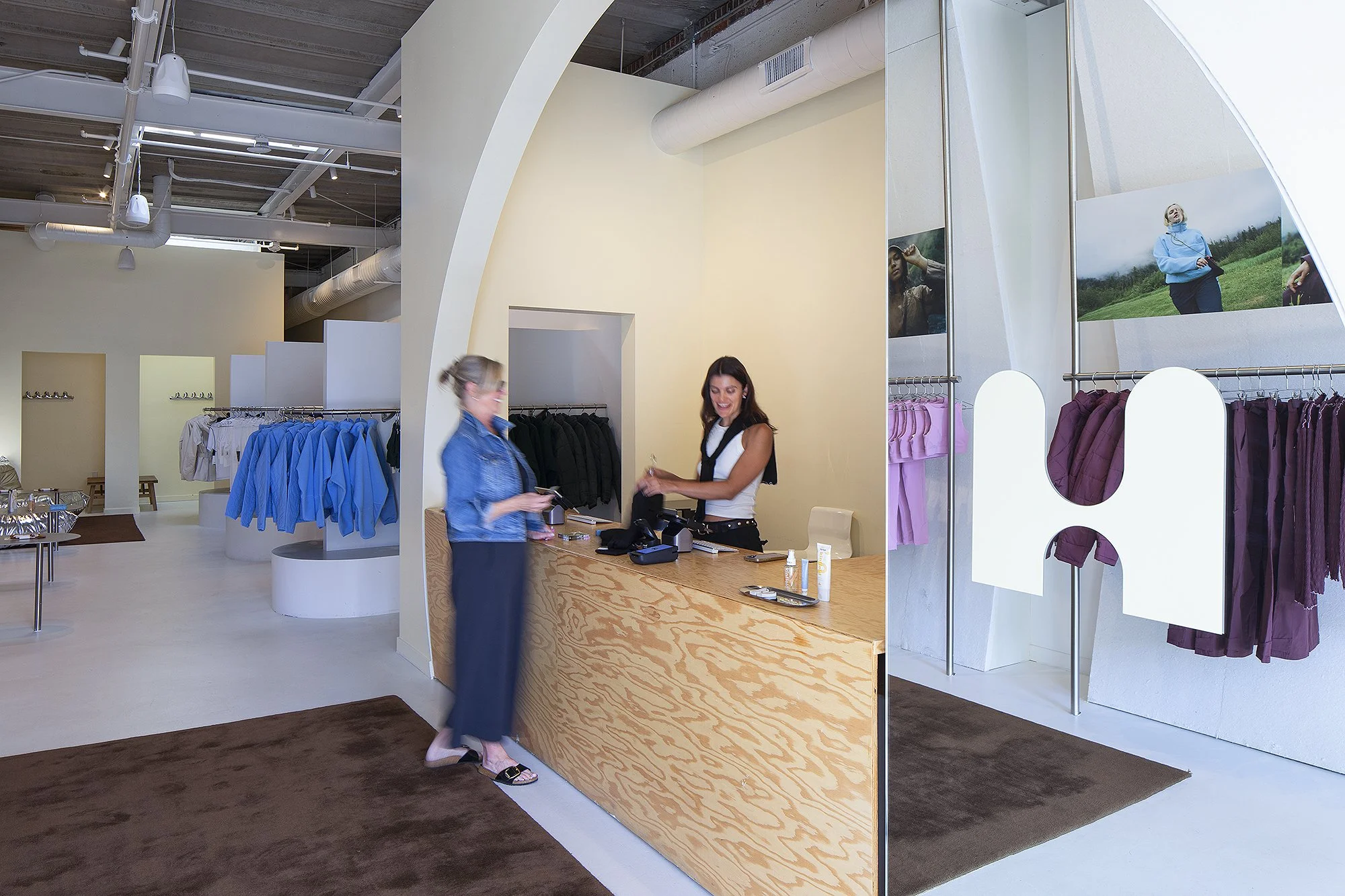 Woman in blue jean jacket making a purchase from a woman in white blouse at Half Days retail store in Denver, Colorado