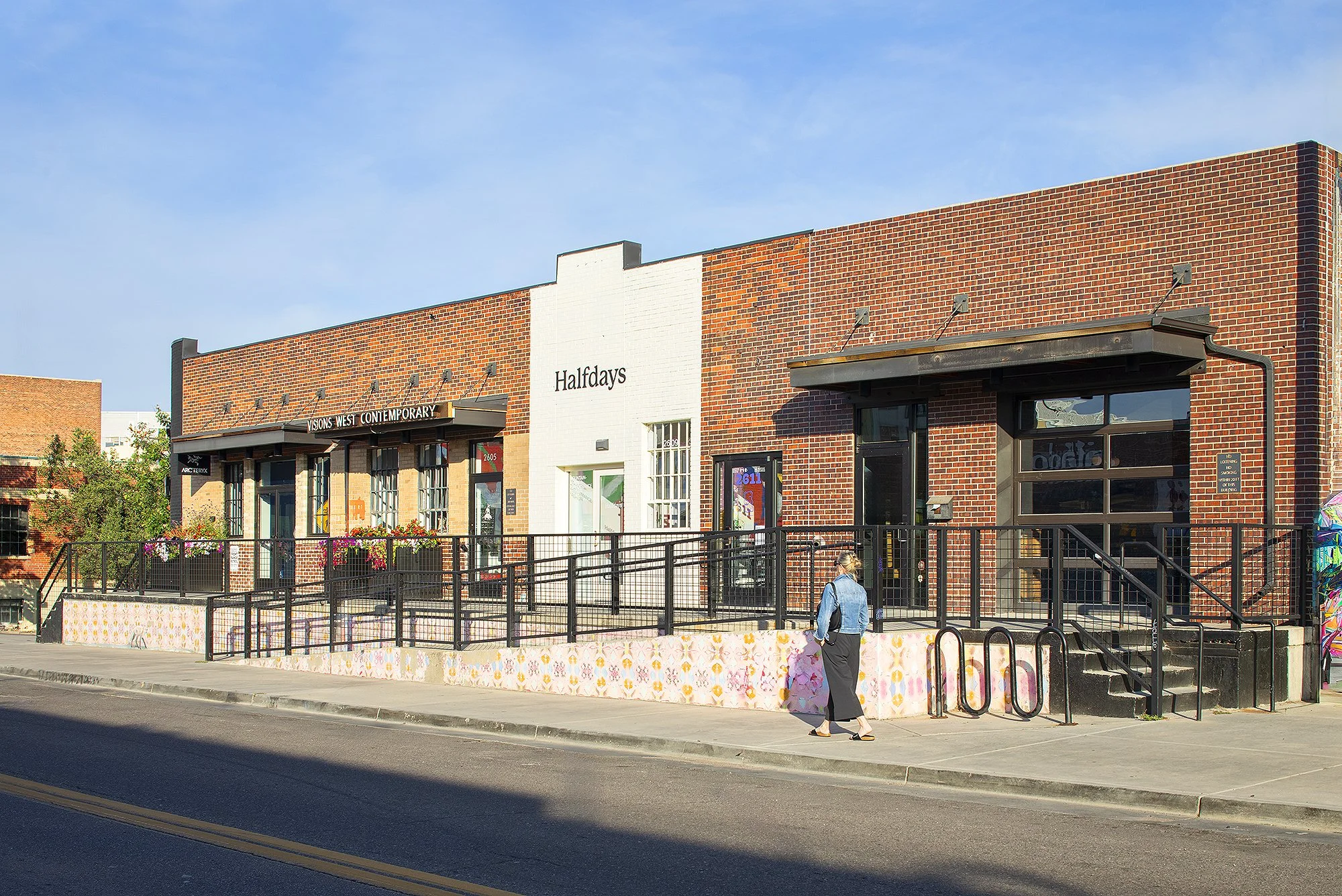 Woman in jean jacket walking in front of brick building in downtown Denver, Colorado